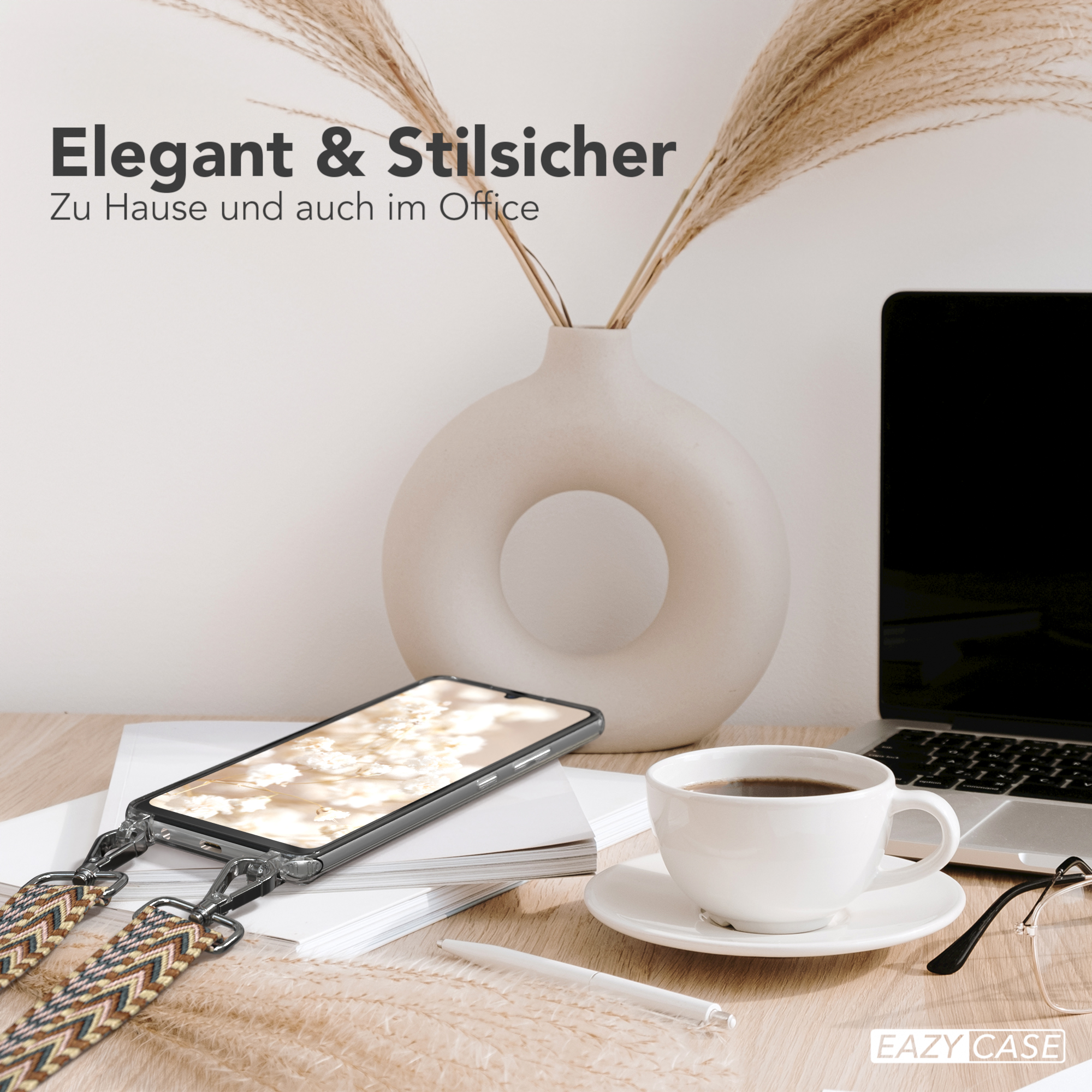 Ein Telefon in einer Hülle steht auf einem Schreibtisch mit einer Kaffeetasse und einer Vase. Die Szene wirkt stilvoll.