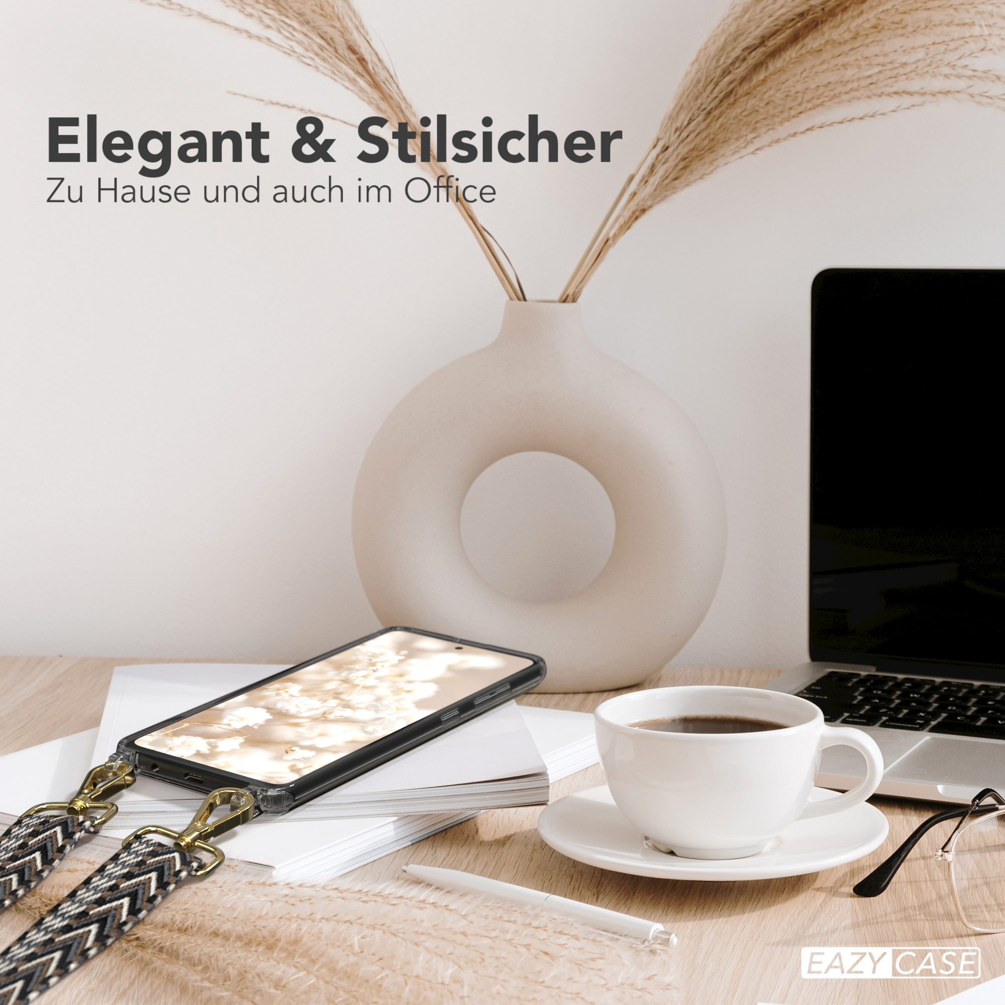 Bürotisch mit Telefon, Kaffeetasse, Brille und Pflanze. Telefon hat gemusterten Riemen.