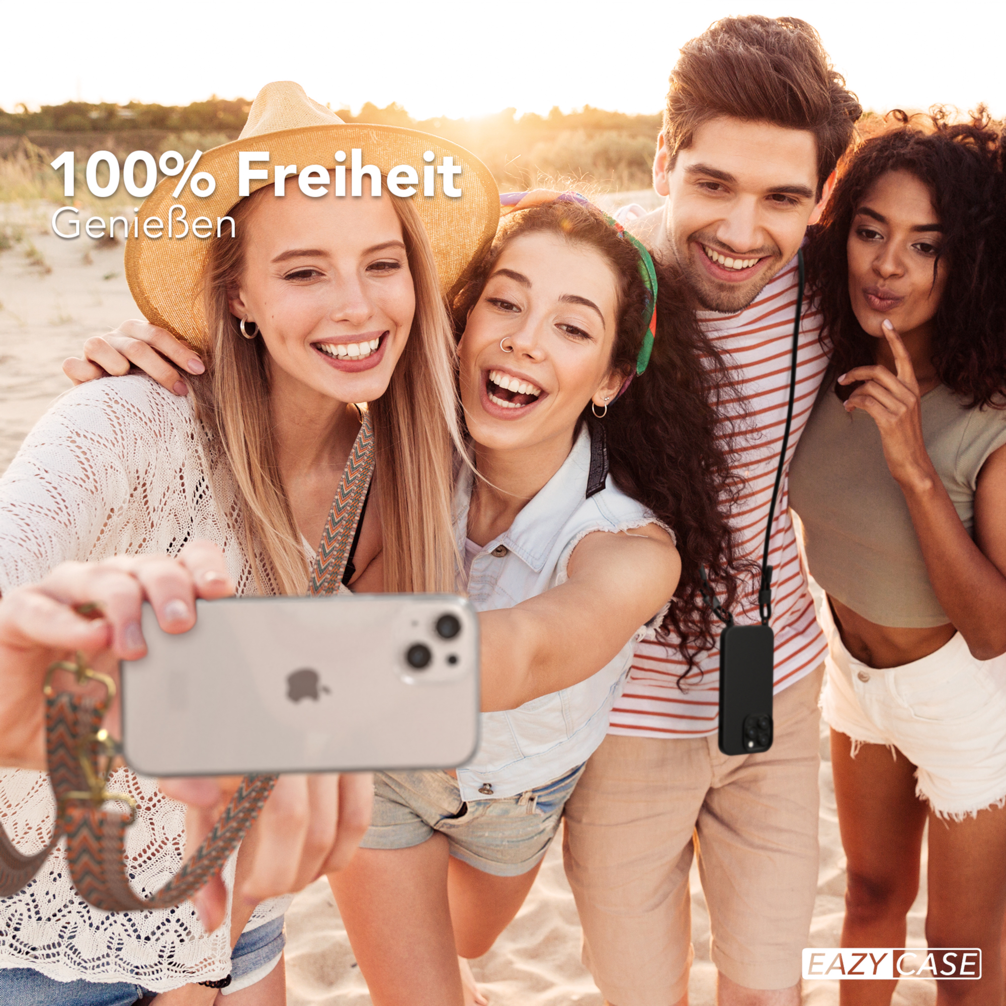 Vier Personen machen ein Selfie am Strand. Sie lächeln und halten ein Telefon mit einem Gurt. Der Hintergrund ist der Strand.