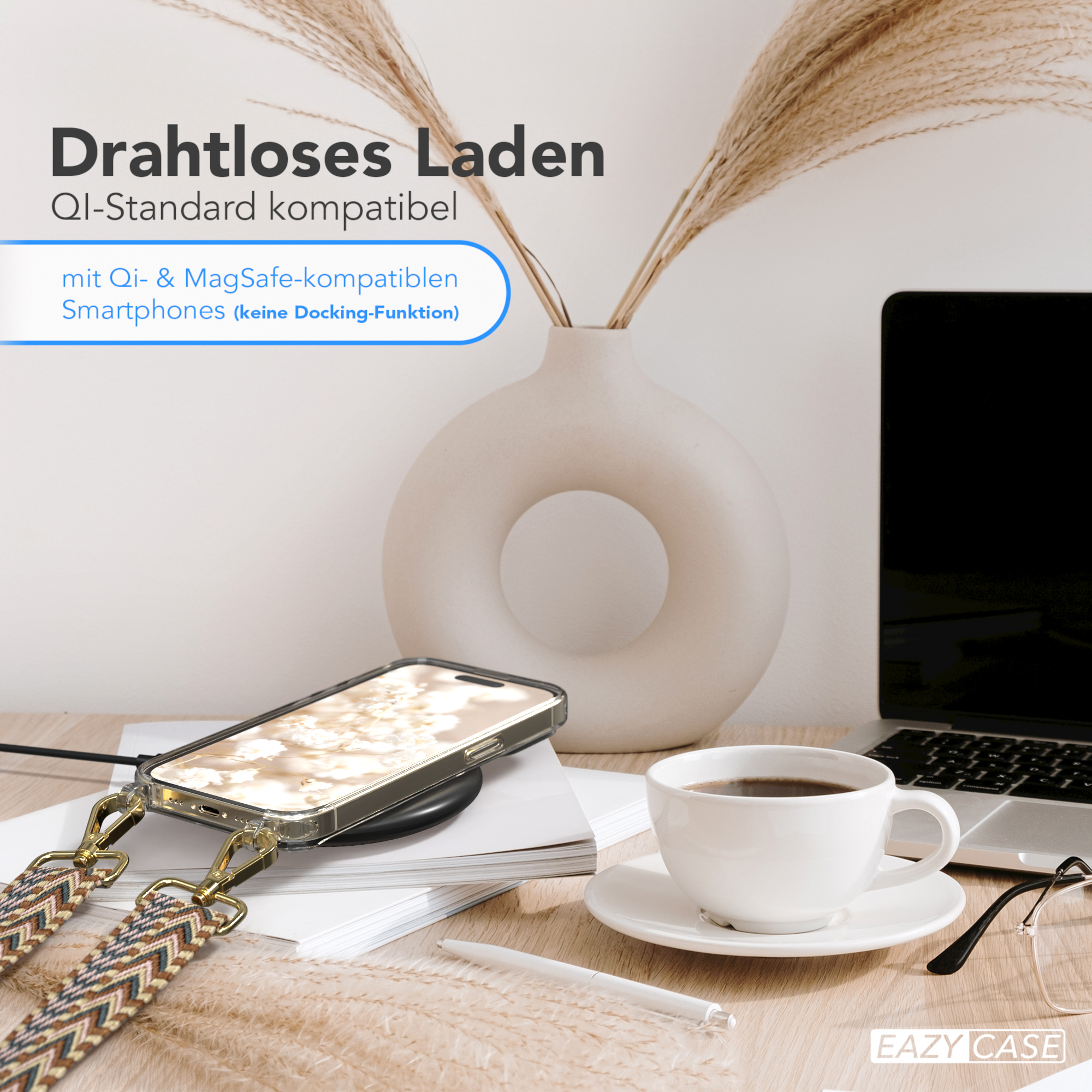 Handy in Hülle auf Ladegerät, neben Kaffee und Laptop. Heller Holztisch.