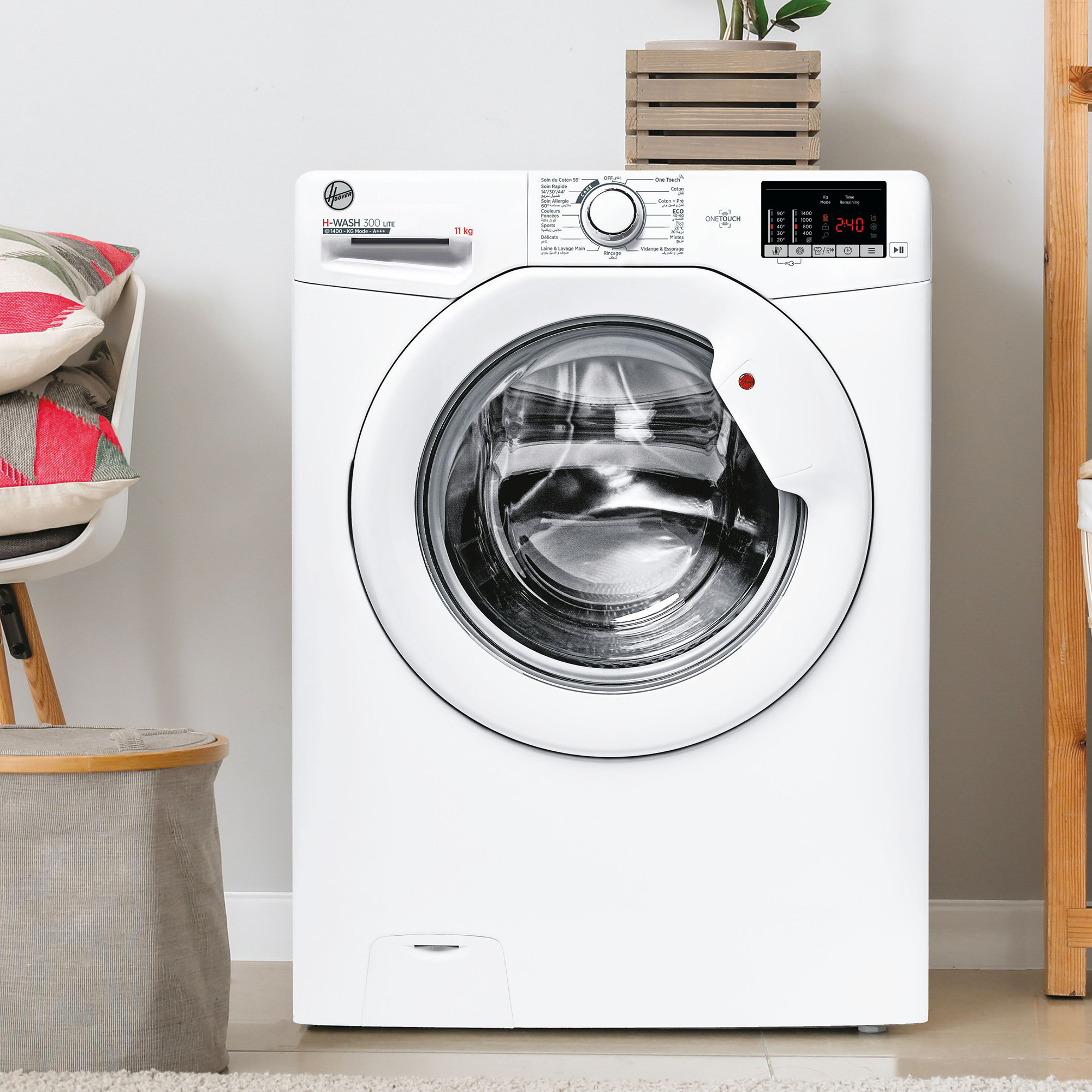 Weiße Hoover H-WASH 300 Waschmaschine mit Digitalanzeige, in der Nähe von Stuhl und Holzregal.