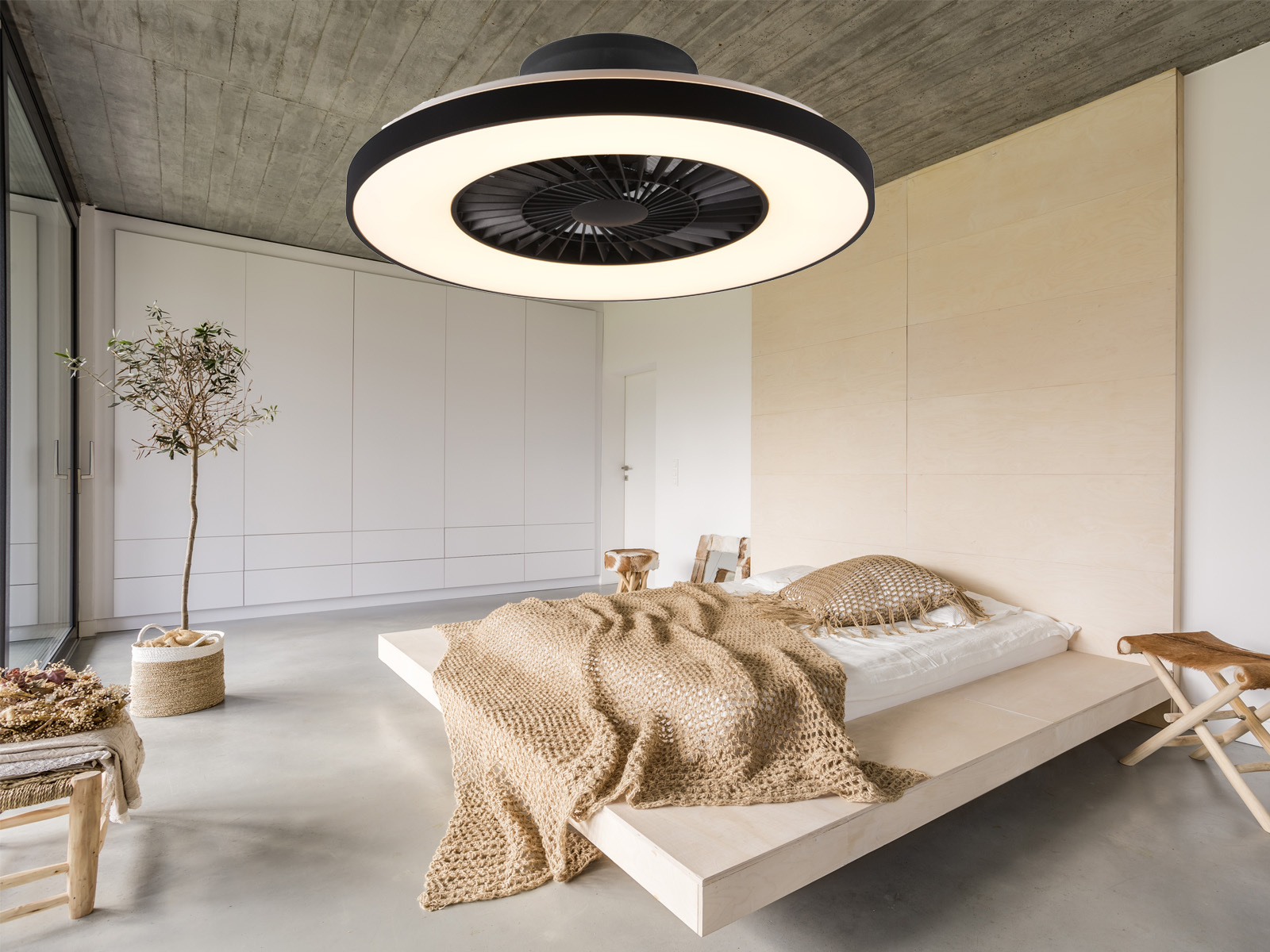 Dormitorio moderno con ventilador de techo circular y cama baja. Diseño minimalista.