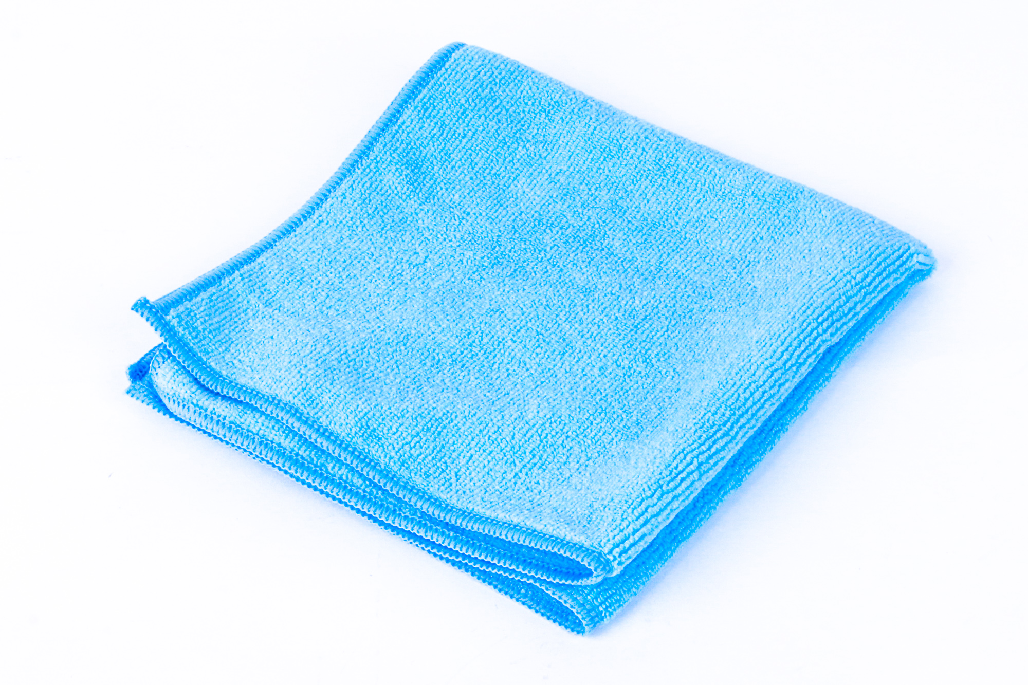 Ein gefaltetes blaues Mikrofaser-Reinigungstuch auf weißem Hintergrund.