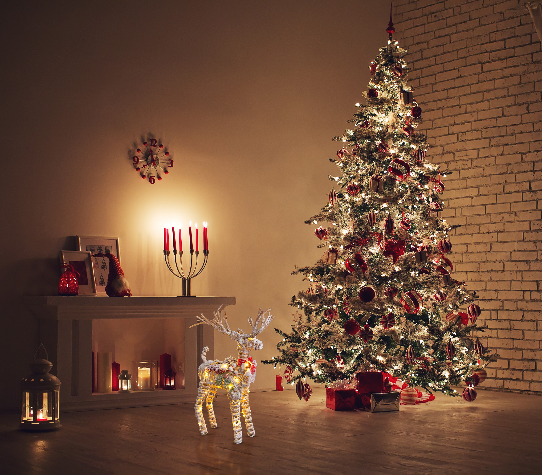 Weihnachtsszene mit Baum, Rentier, Kerzen und Kamin.