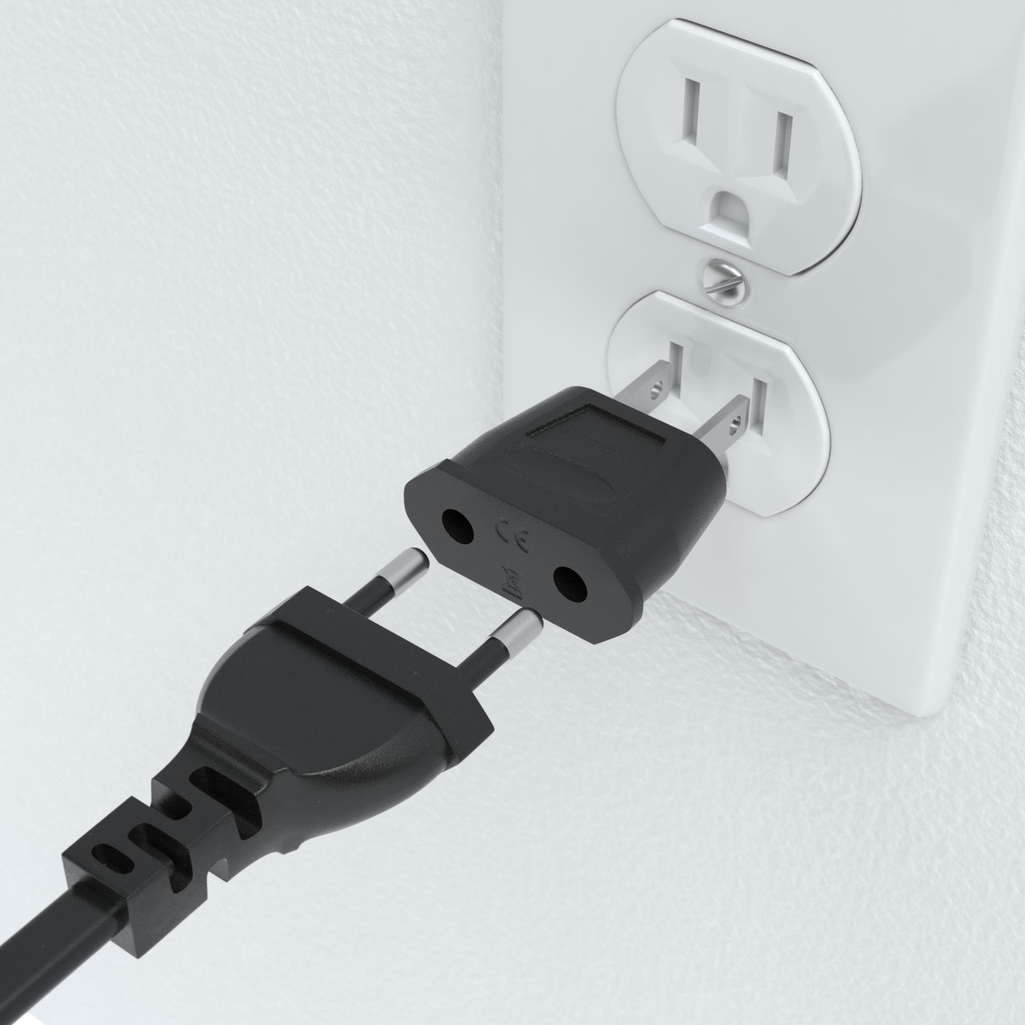 Schwarzer Steckeradapter, der in eine Steckdose gesteckt wird. Die Steckdose ist weiß.