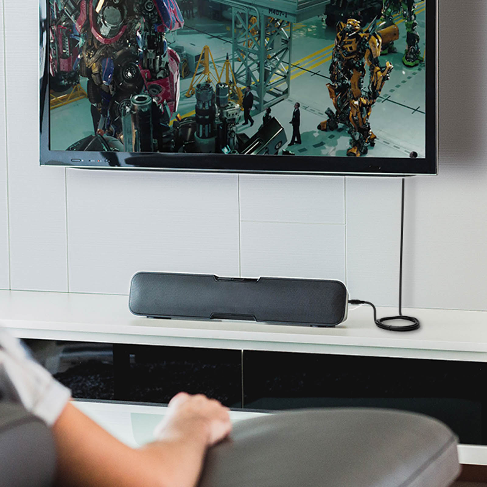 Una soundbar sotto un televisore che mostra una scena del film Transformers.