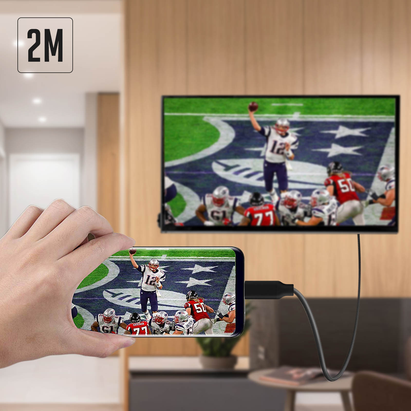 Mano che tiene un telefono che mostra una partita di football, collegato a una TV.