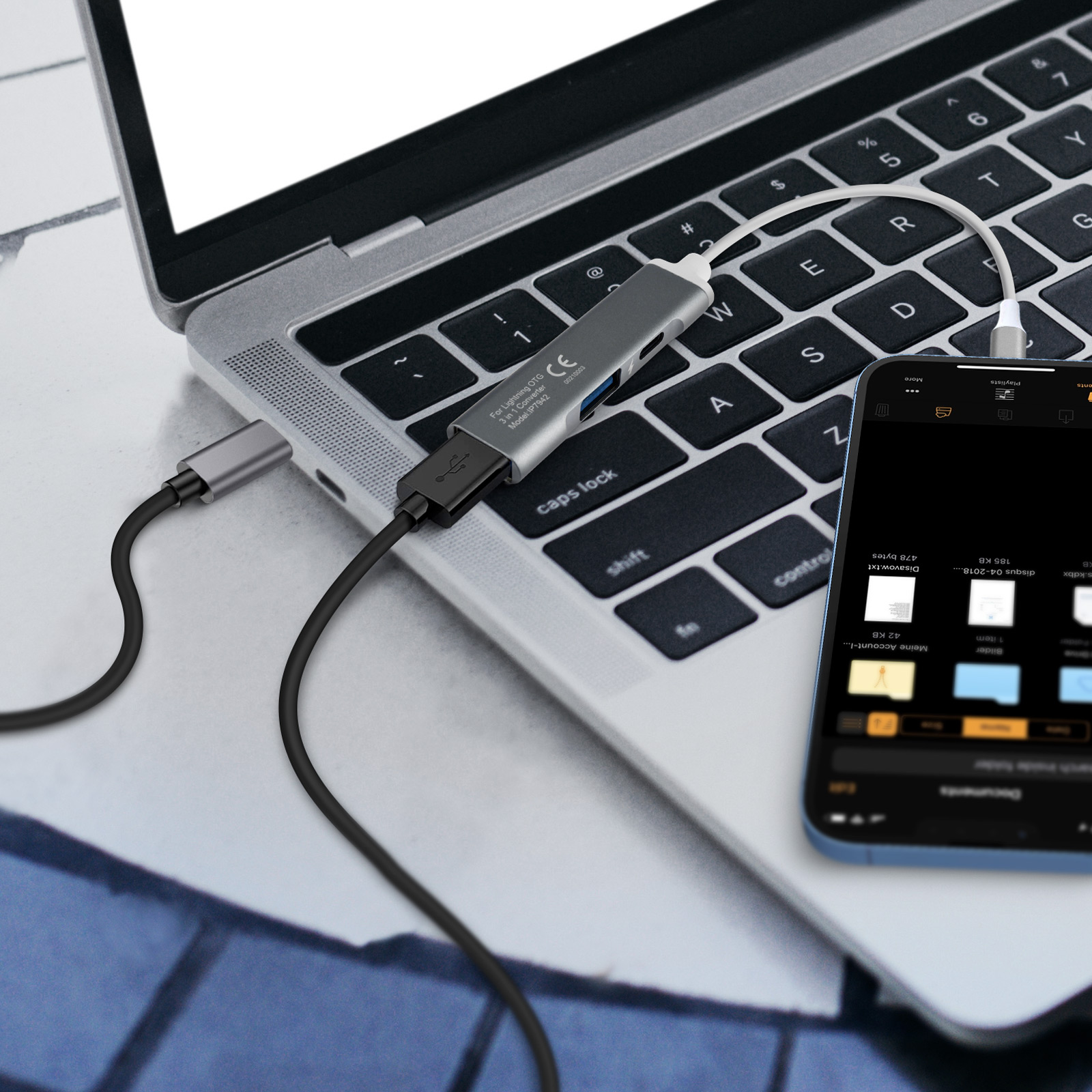 Un ordinateur portable avec un hub USB-C connecté à un téléphone, affichant un gestionnaire de fichiers.