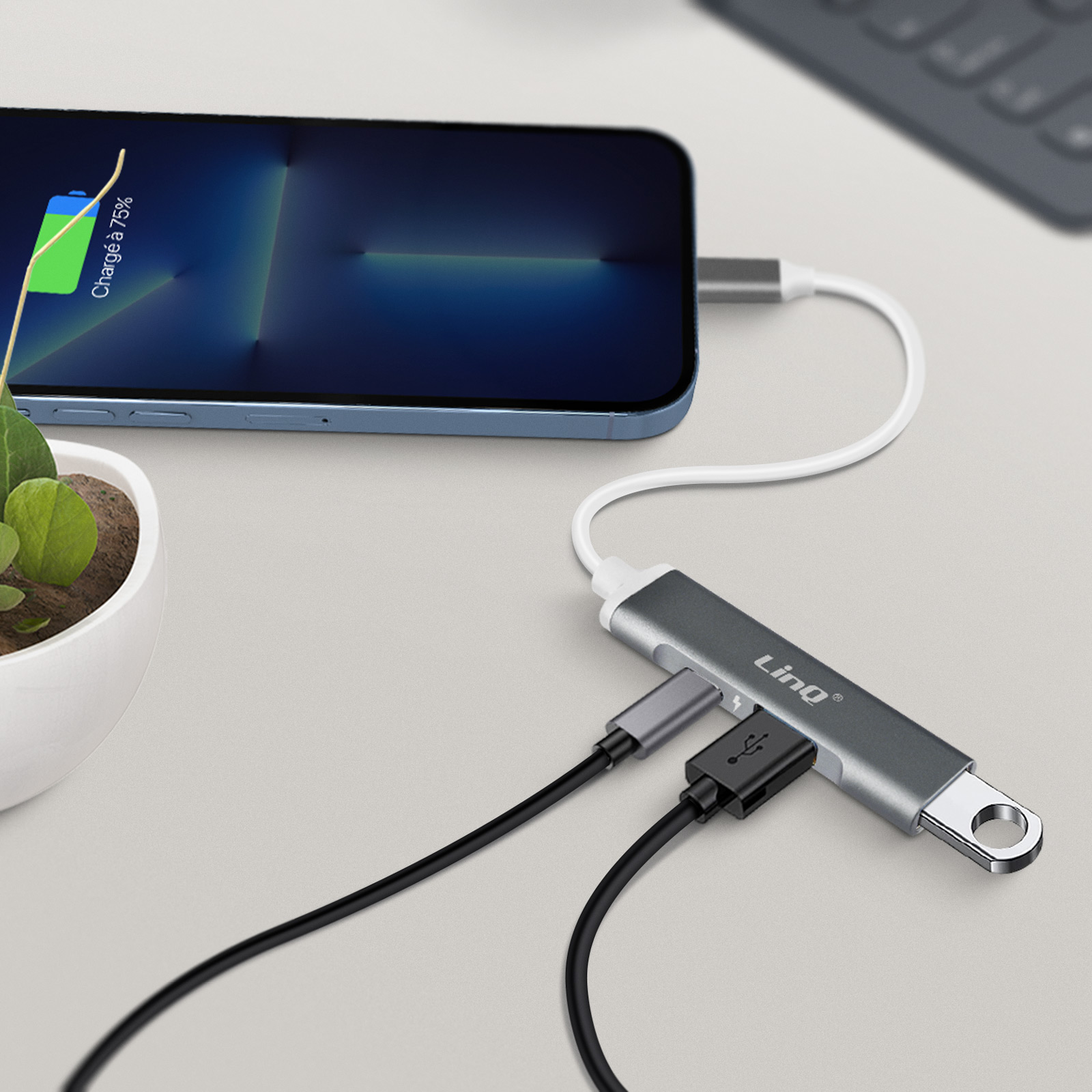 Téléphone en charge avec un hub USB connecté. Le téléphone est en charge.