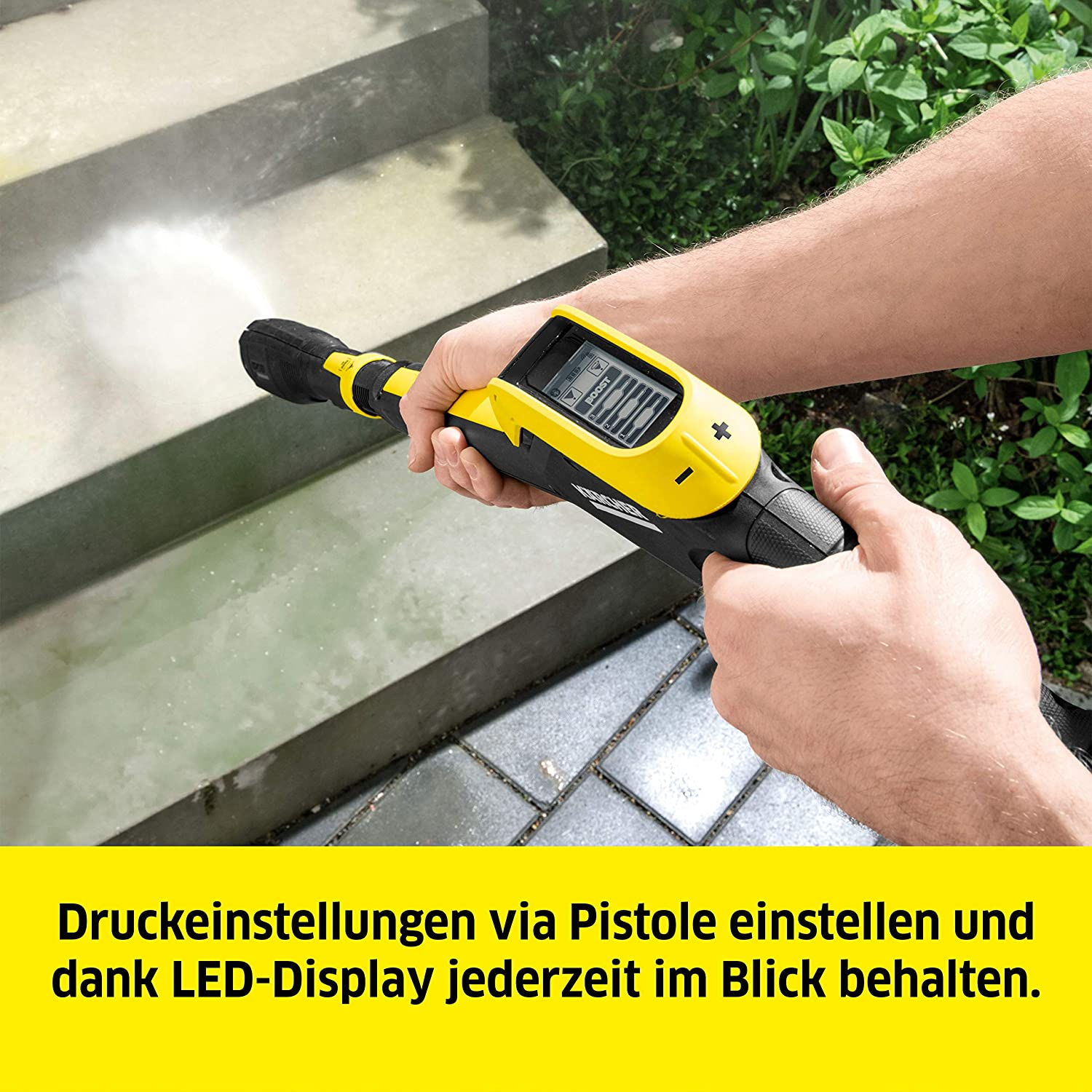 Eine Person hält einen gelb-schwarzen Hochdruckreiniger und sprüht Wasser auf Stufen, Nahaufnahme.