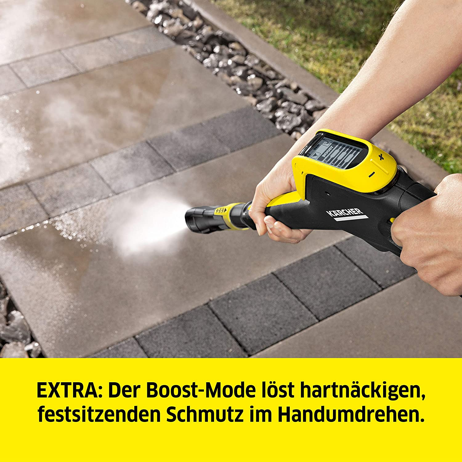 Eine Person, die einen gelb-schwarzen Hochdruckreiniger auf einer Steinoberfläche verwendet.