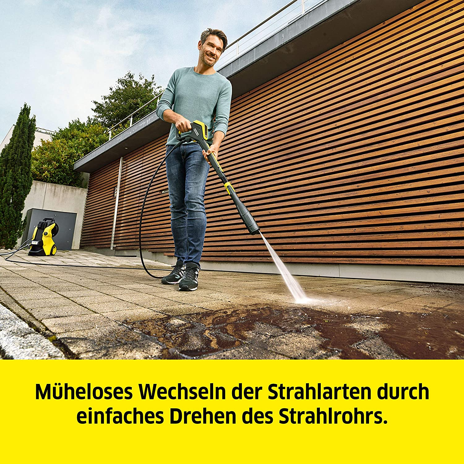 Un uomo usa un'idropulitrice su un patio.