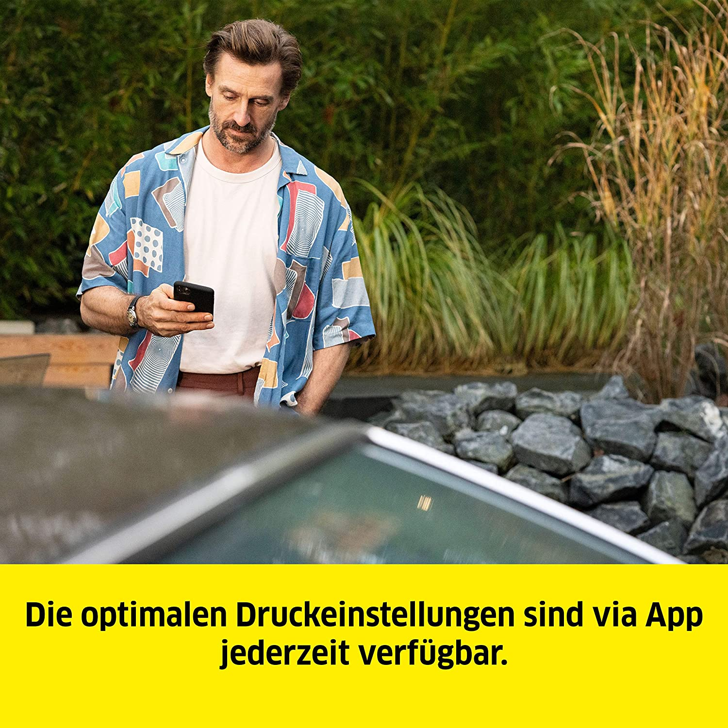 Mężczyzna korzystający z telefonu na zewnątrz. Tekst po niemiecku.