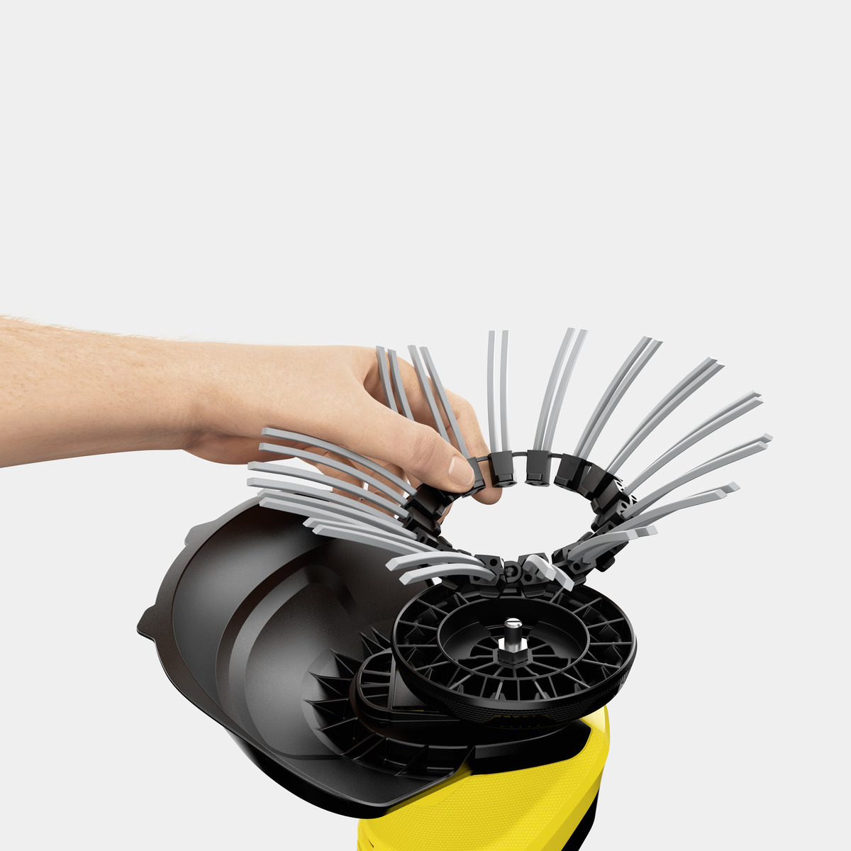 Dłoń trzymająca obrotową szczotkę do urządzenia czyszczącego, ujęcie z bliska.