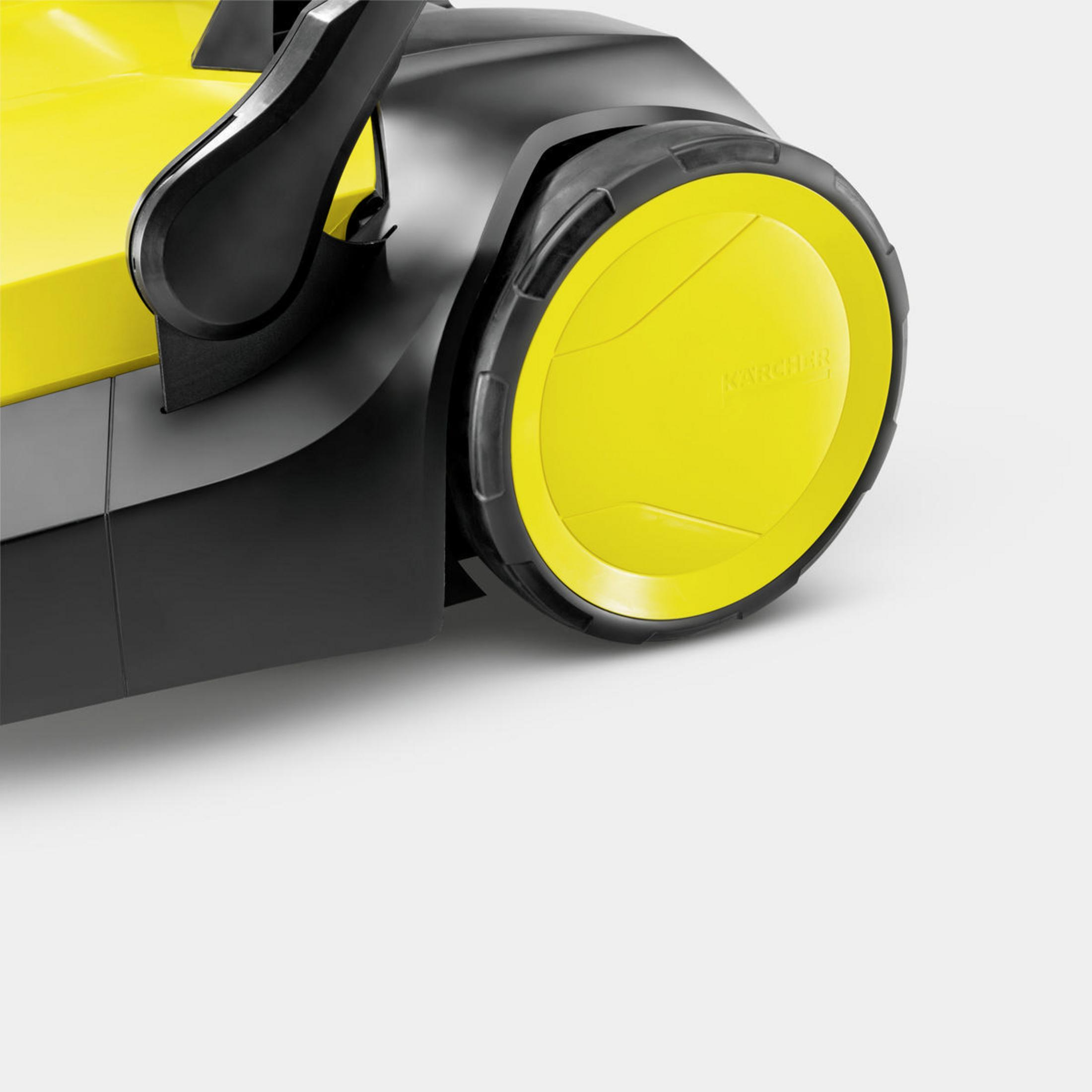 Primer plano de una rueda barredora amarilla y negra. La rueda tiene un borde negro y un centro amarillo.