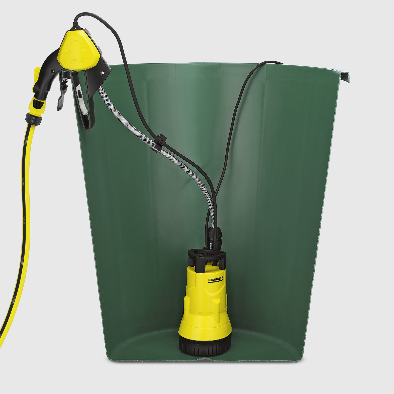 Una bomba de agua amarilla y negra dentro de un recipiente verde. Una manguera y una boquilla están adjuntas.