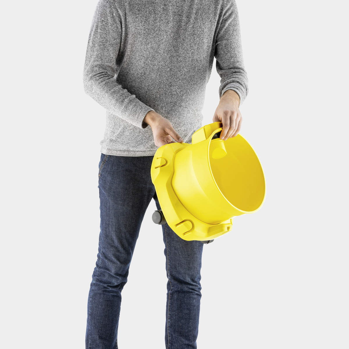 Un uomo che tiene un secchio giallo con una maniglia. Il secchio è inclinato, mostrando l'interno.