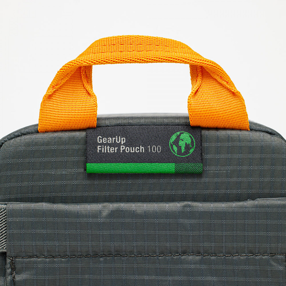 Grauer Filterbeutel mit orangefarbenem Griff. Aufkleber mit der Aufschrift 'GearUp Filter Pouch 100'.