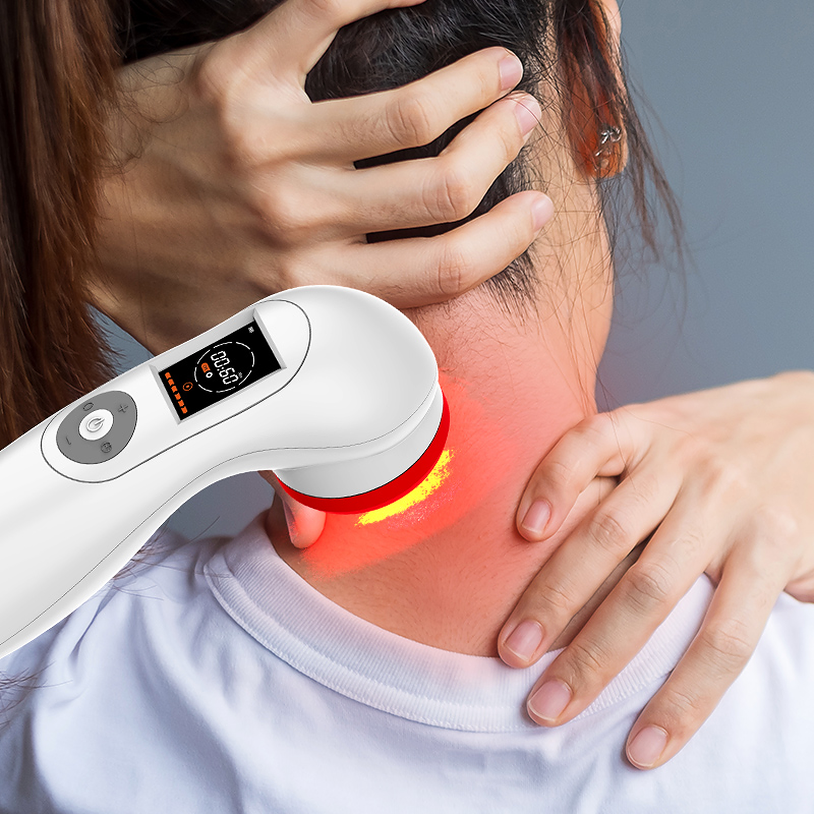 Der Nacken einer Person wird mit einem Rotlichttherapiegerät behandelt.