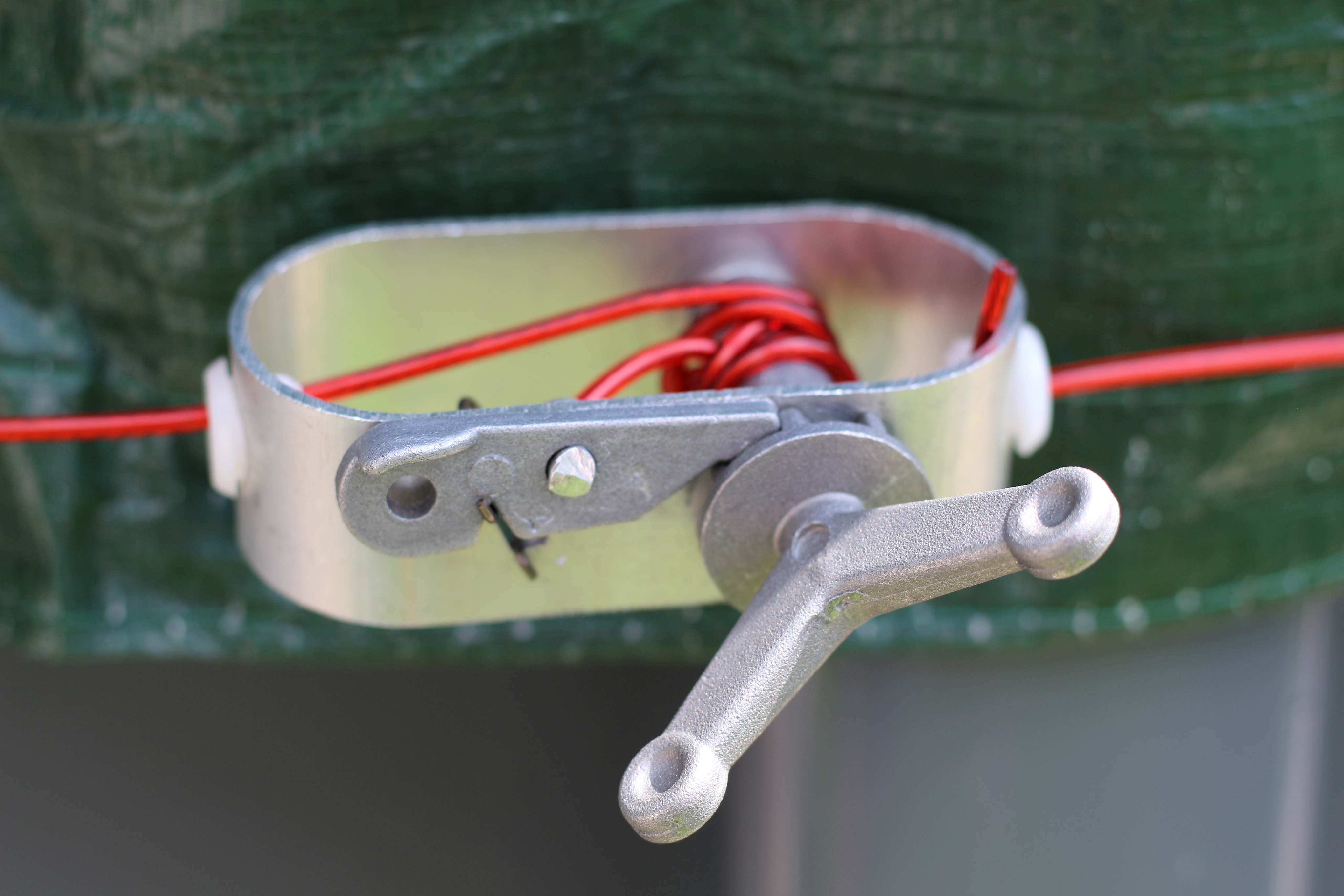 Nahaufnahme eines Metall- und Kunststoffmechanismus mit roten Drähten.