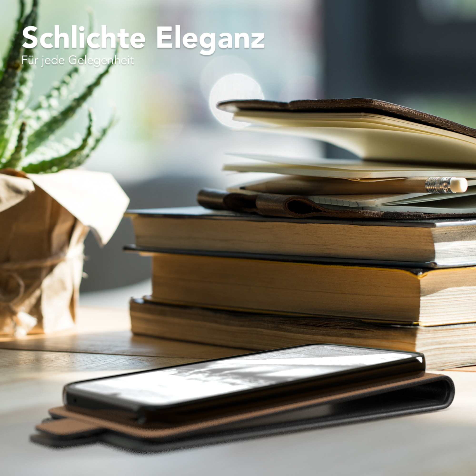 Ein Telefon in einer braunen Lederhülle auf einer Holzoberfläche, mit Büchern und einer Pflanze im Hintergrund.