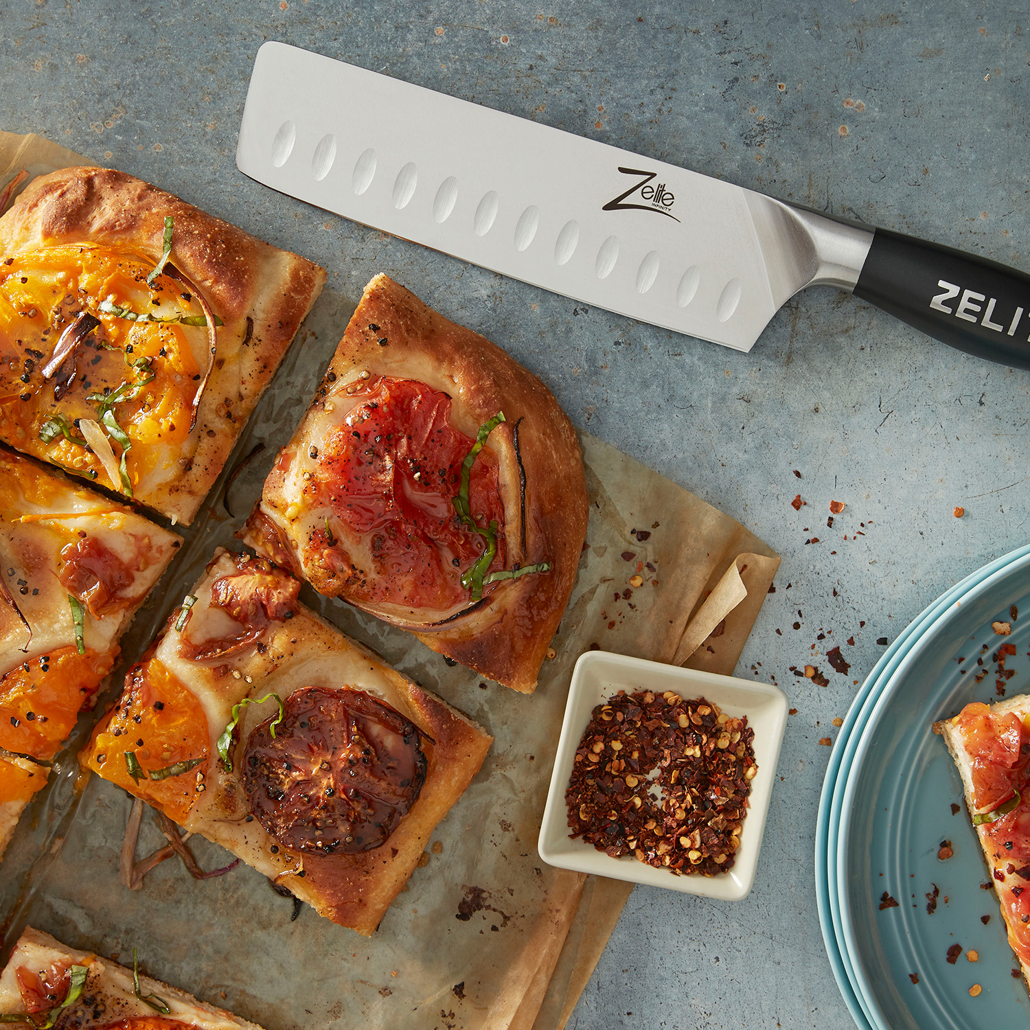 Ein Messer mit schwarzem Griff schneidet Pizza auf Holz mit Belägen.