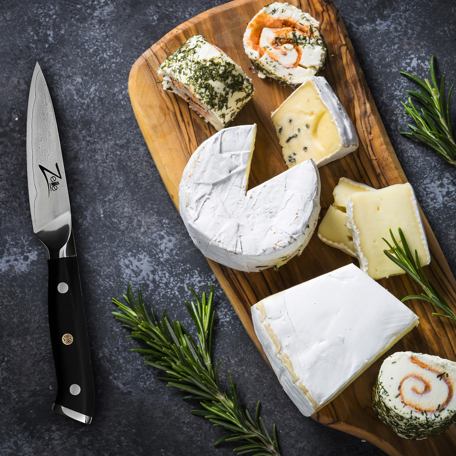 Draufsicht auf Holzbrett mit Käse, Messer und Rosmarin auf dunkler Oberfläche.