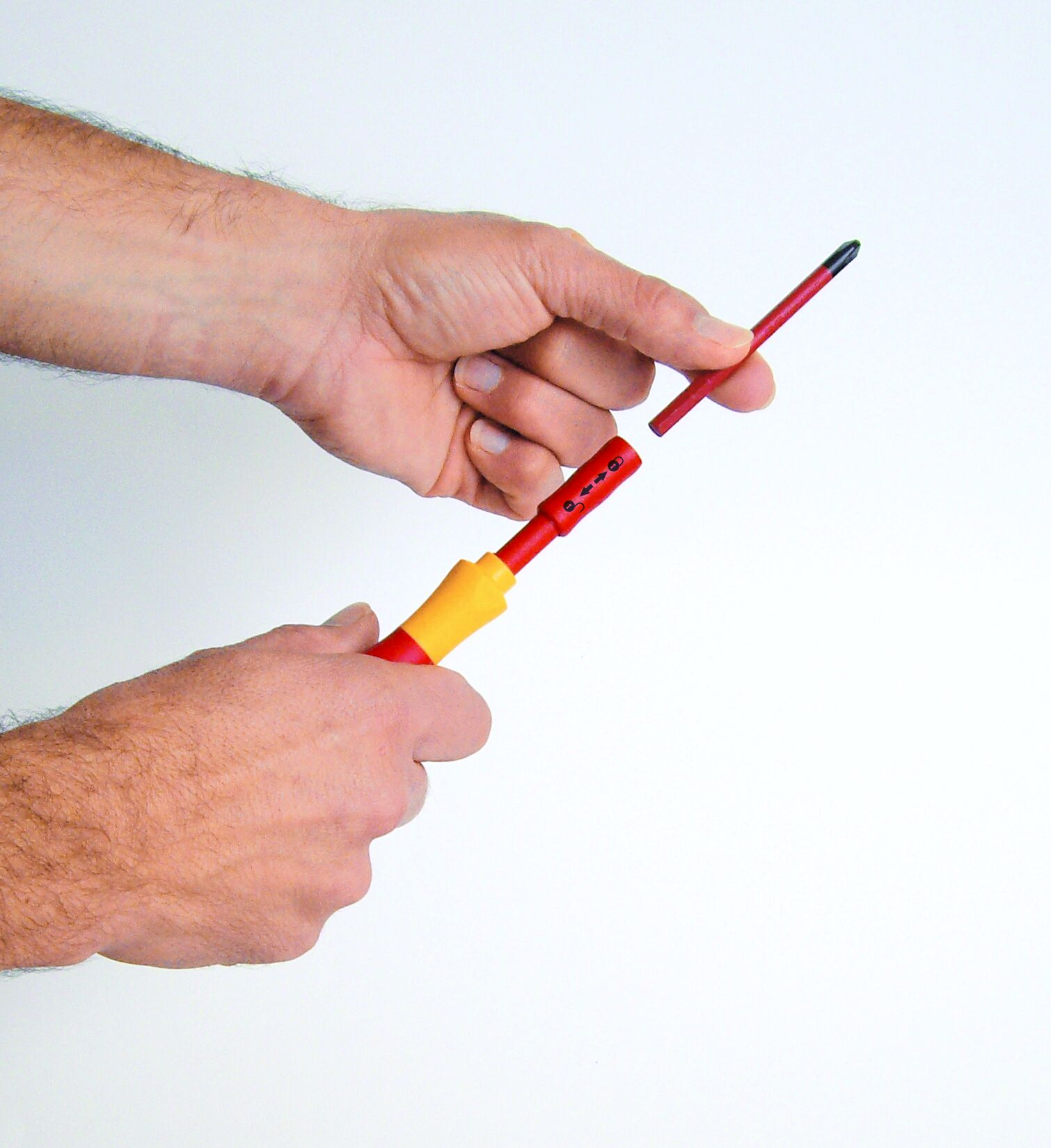 Ręce montujące czerwono-żółty śrubokręt. Śrubokręt ma odczepianą końcówkę.