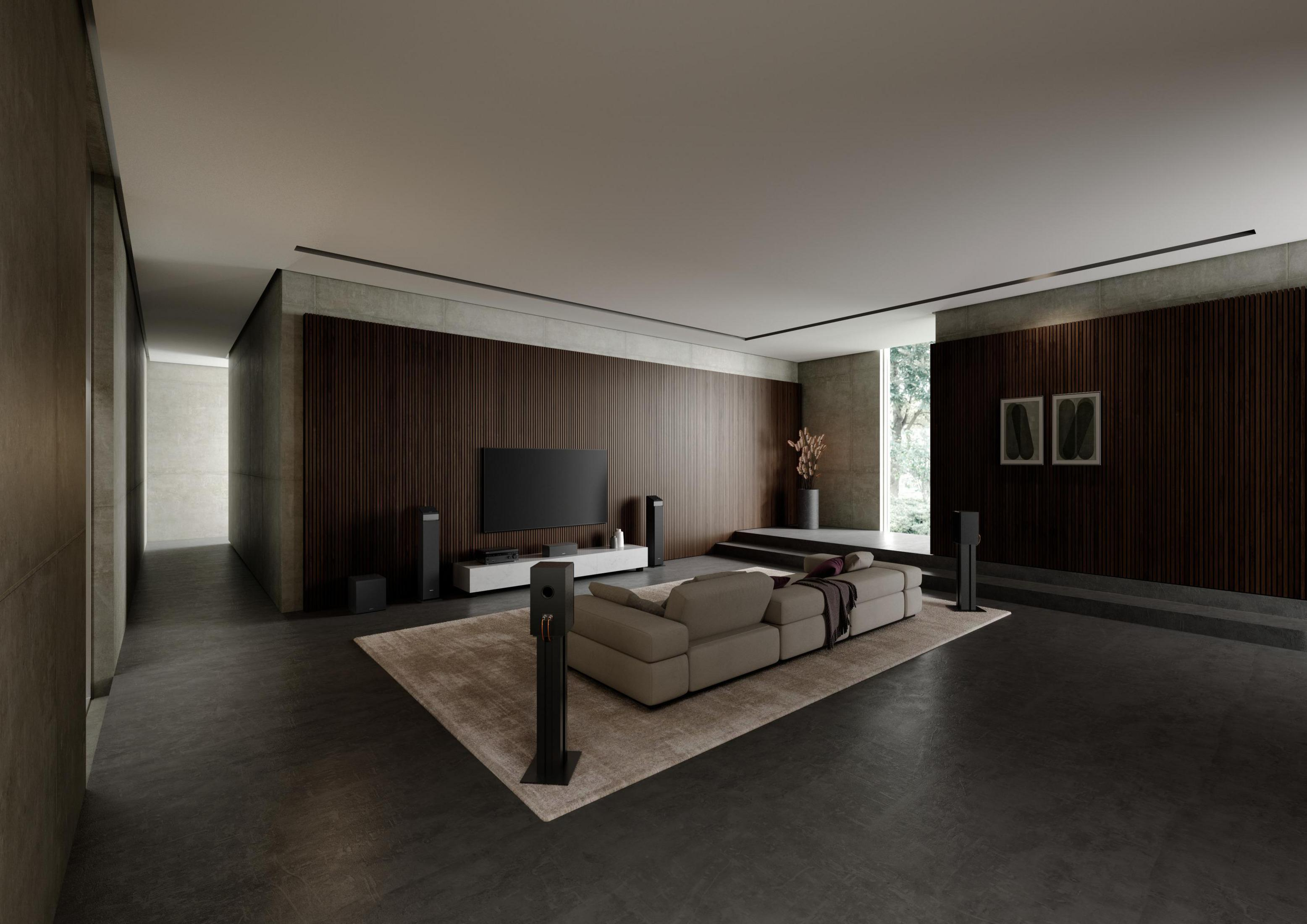 Ein modernes Wohnzimmer mit großem Sofa, TV und Lautsprechern.