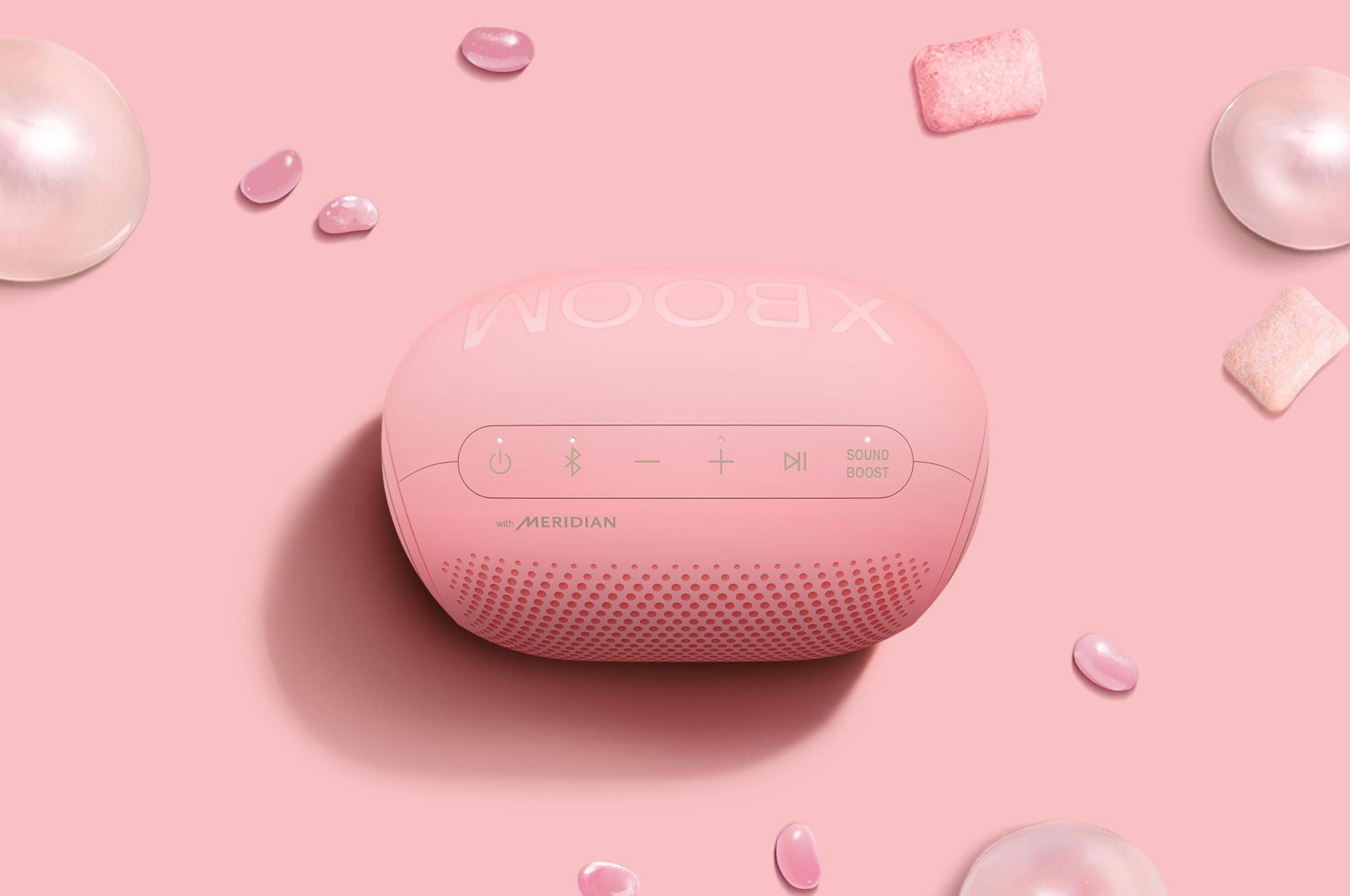 Altoparlante LG XBOOM rosa circondato da gomma da masticare rosa e perle. Sfondo rosa.
