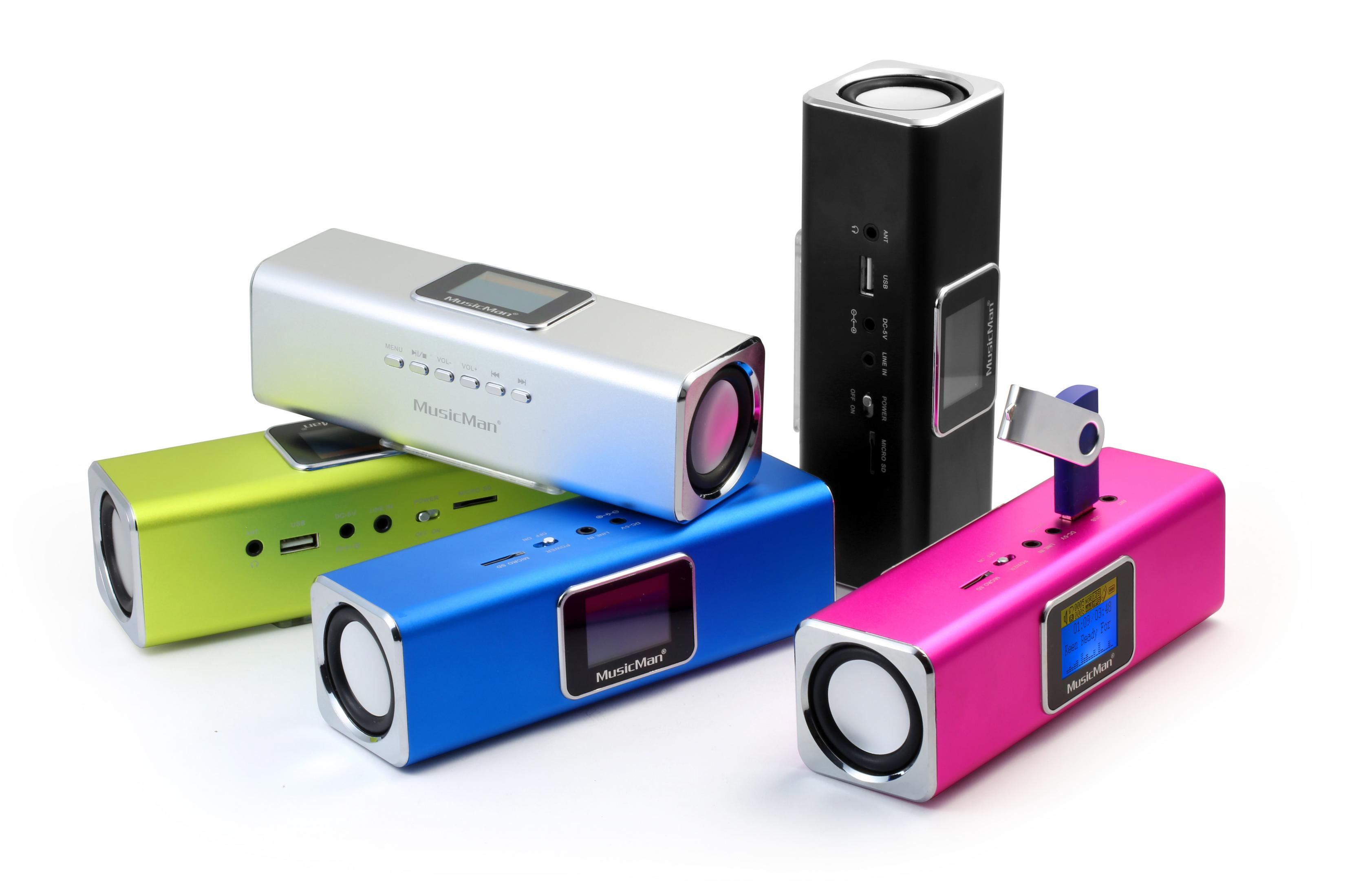 Wiele głośników w różnych kolorach, cylindrycznych z głośnikiem na każdym końcu, ułożonych na białej powierzchni.