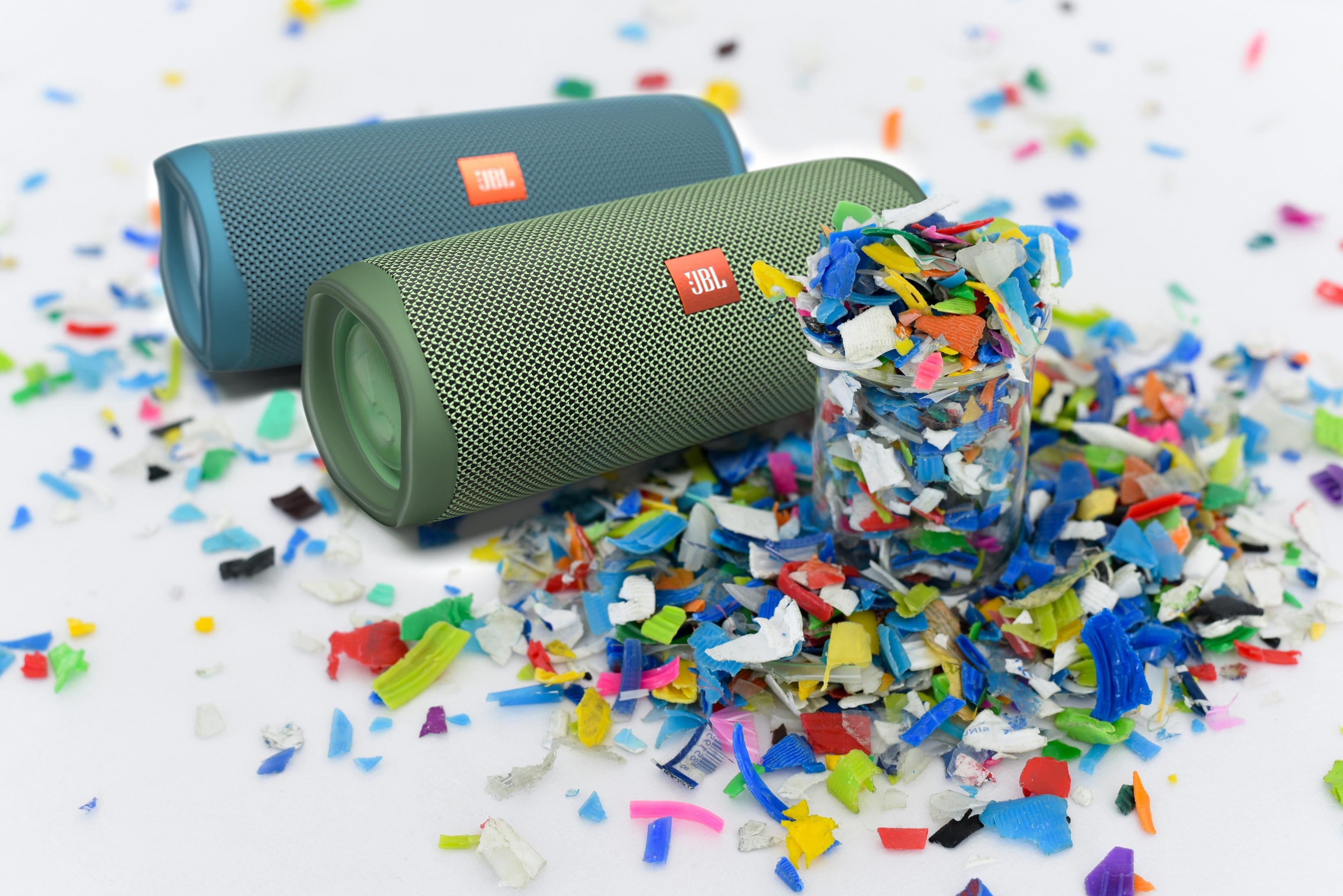 Due altoparlanti JBL e pezzi di plastica colorati. Sfondo bianco.