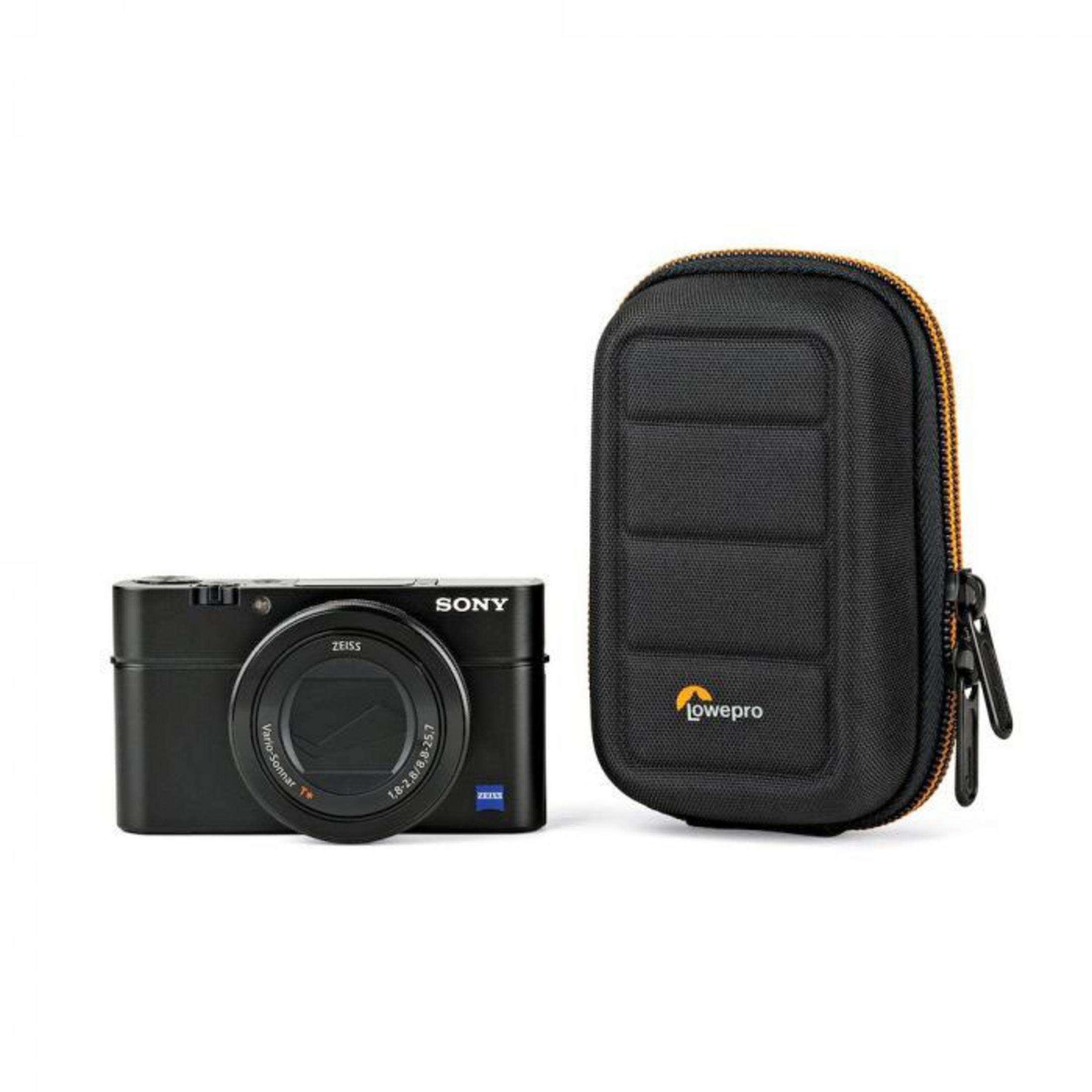 Eine Sony Kamera und ein Lowepro Etui liegen auf einer weißen Oberfläche.