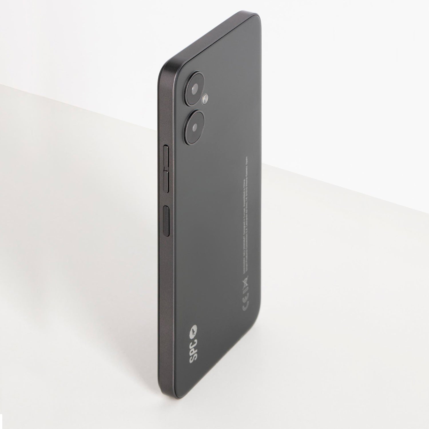 Smartphone negro en ángulo. Tiene cámaras dobles, botones de volumen y el logotipo de SPC.