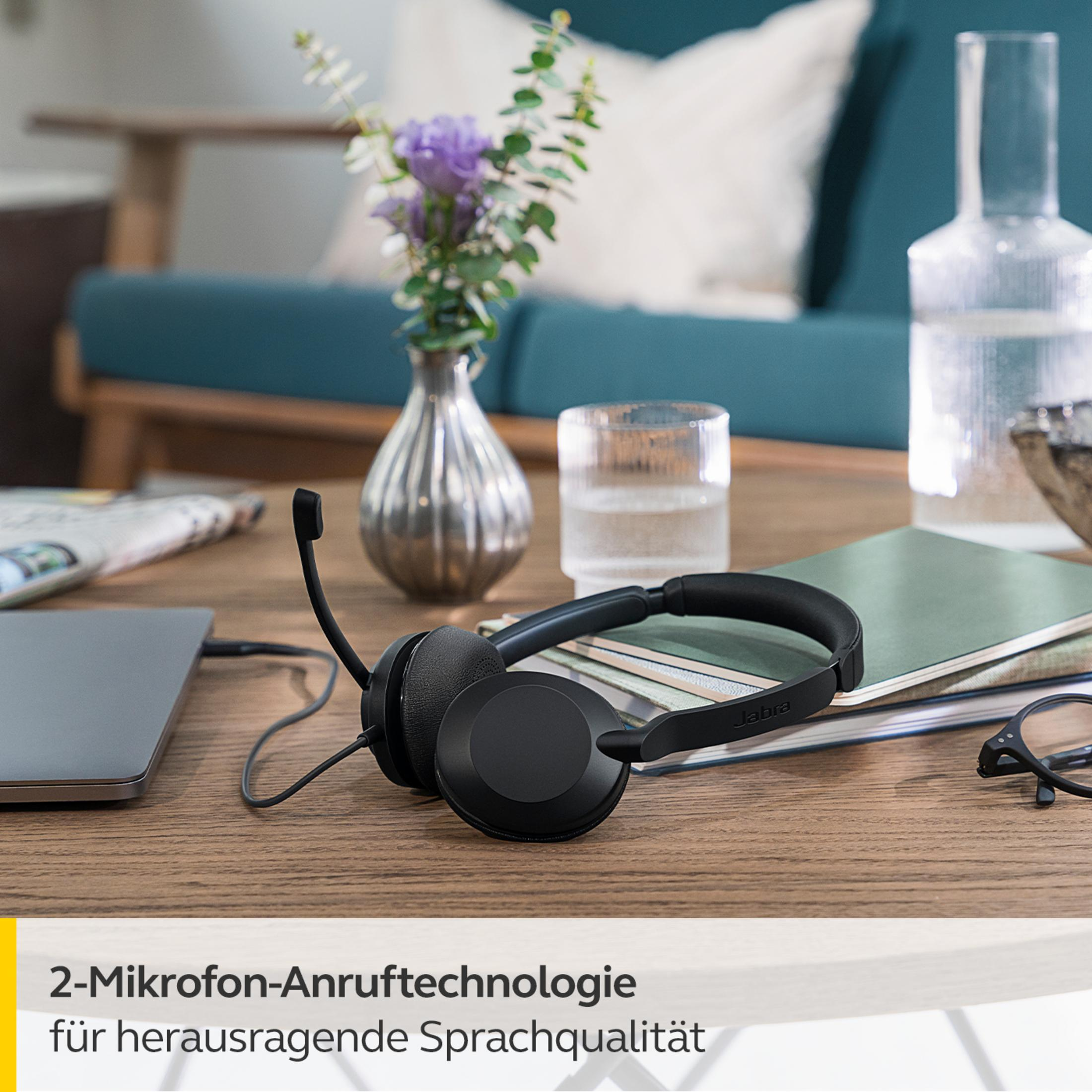 Schwarzes Headset mit Mikrofon auf einem Holztisch. Text unten: 2-Mikrofon-Anruftechnologie.