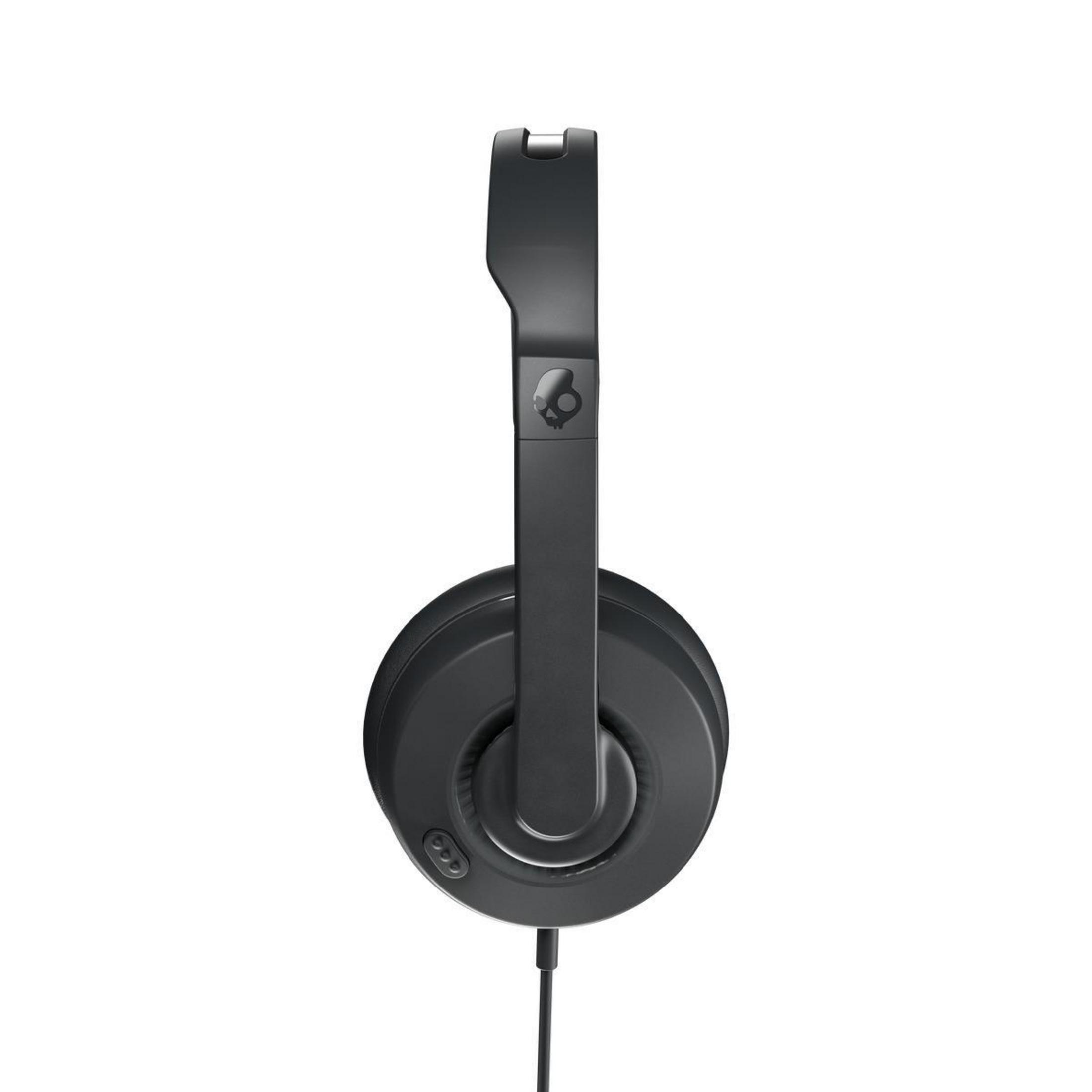 Black Skullcandy headphones, side view, black background.
