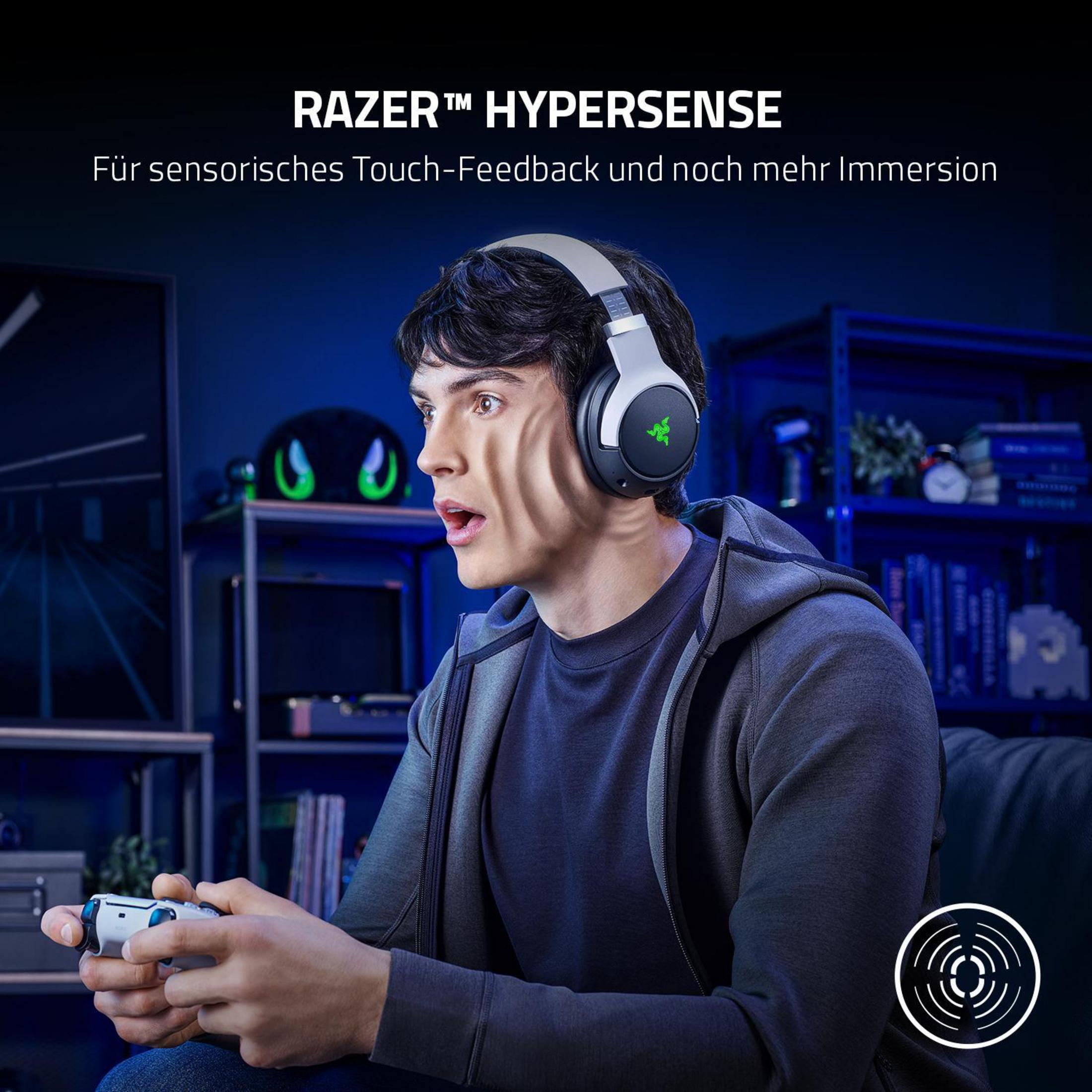 Ein Mann mit Kopfhörern spielt ein Spiel und hält einen Controller. Der Text lautet: RAZER HYPERSENSE.
