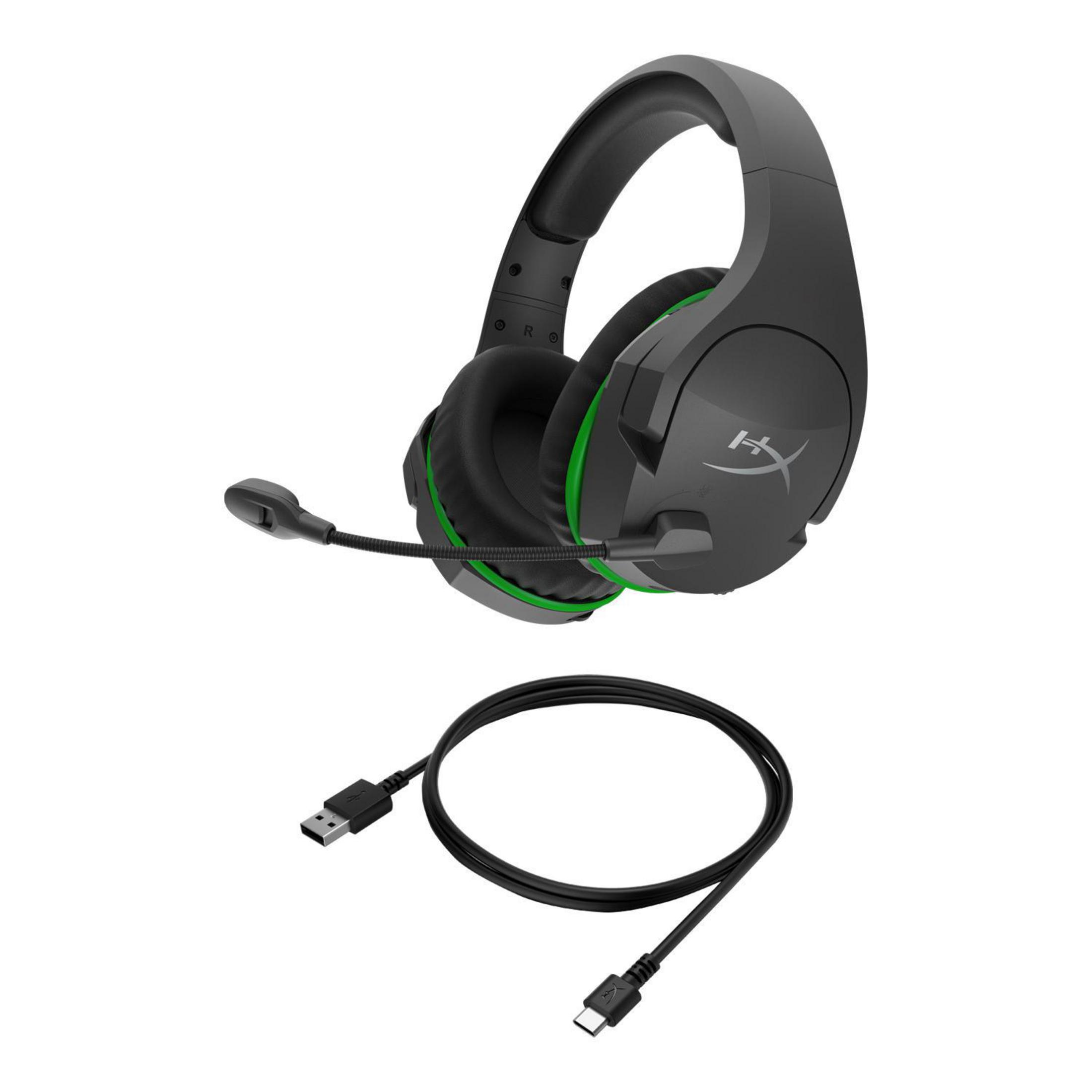 Schwarzes und grünes Gaming-Headset und ein schwarzes USB-Kabel auf weißem Hintergrund, schräge Ansicht.