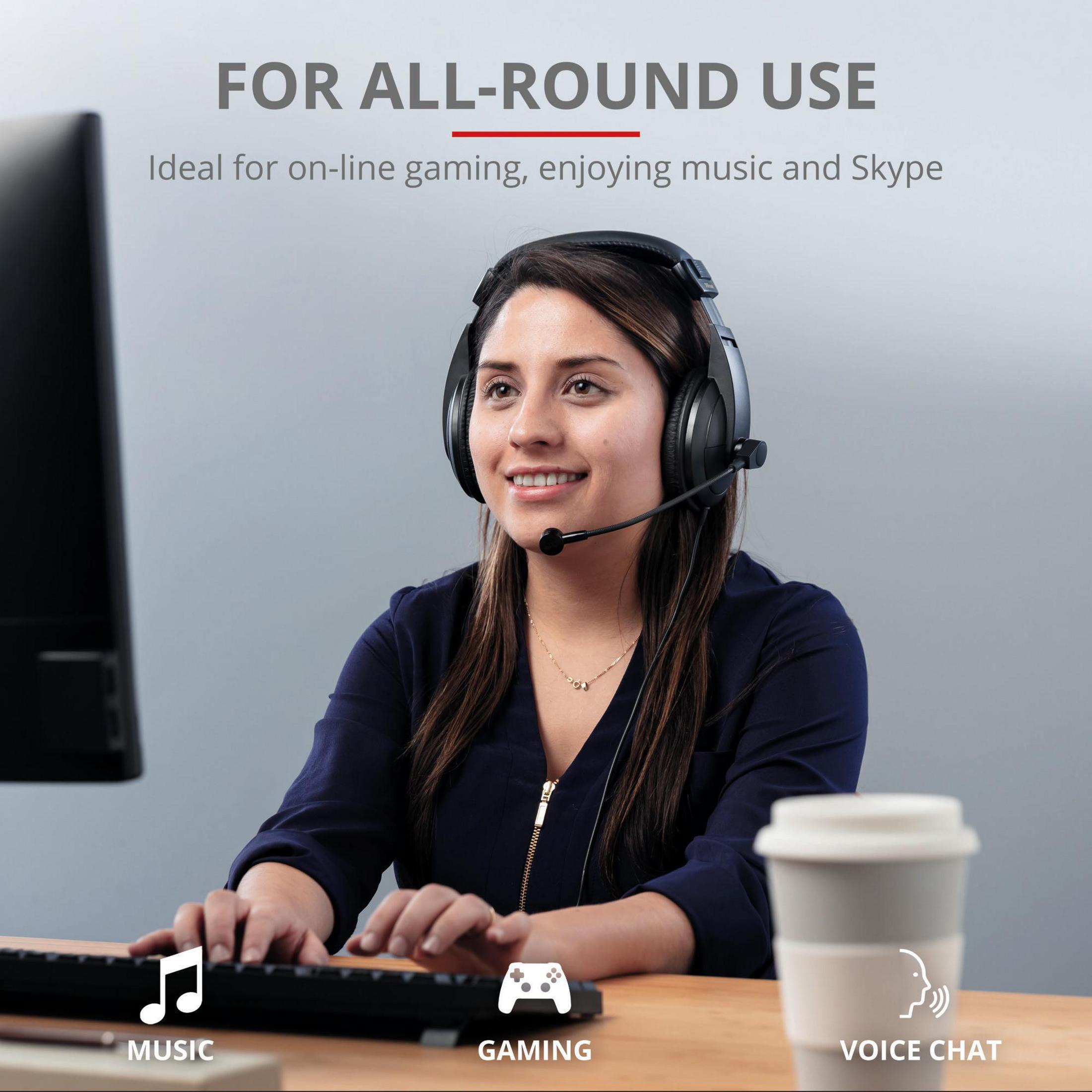 Eine Frau benutzt ein Headset, während sie an einem Computer arbeitet.
