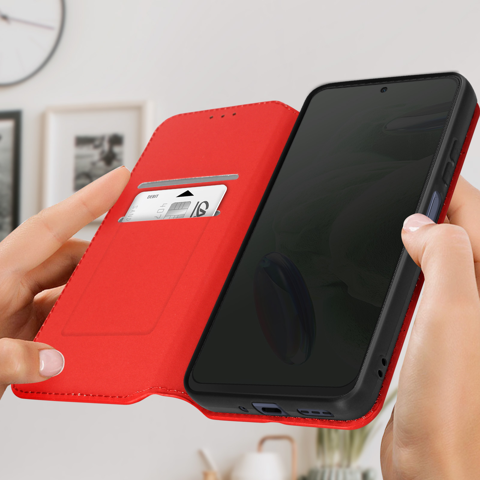 Custodia rossa per telefono aperta. Telefono dentro e carta nello slot. Mani che la tengono.