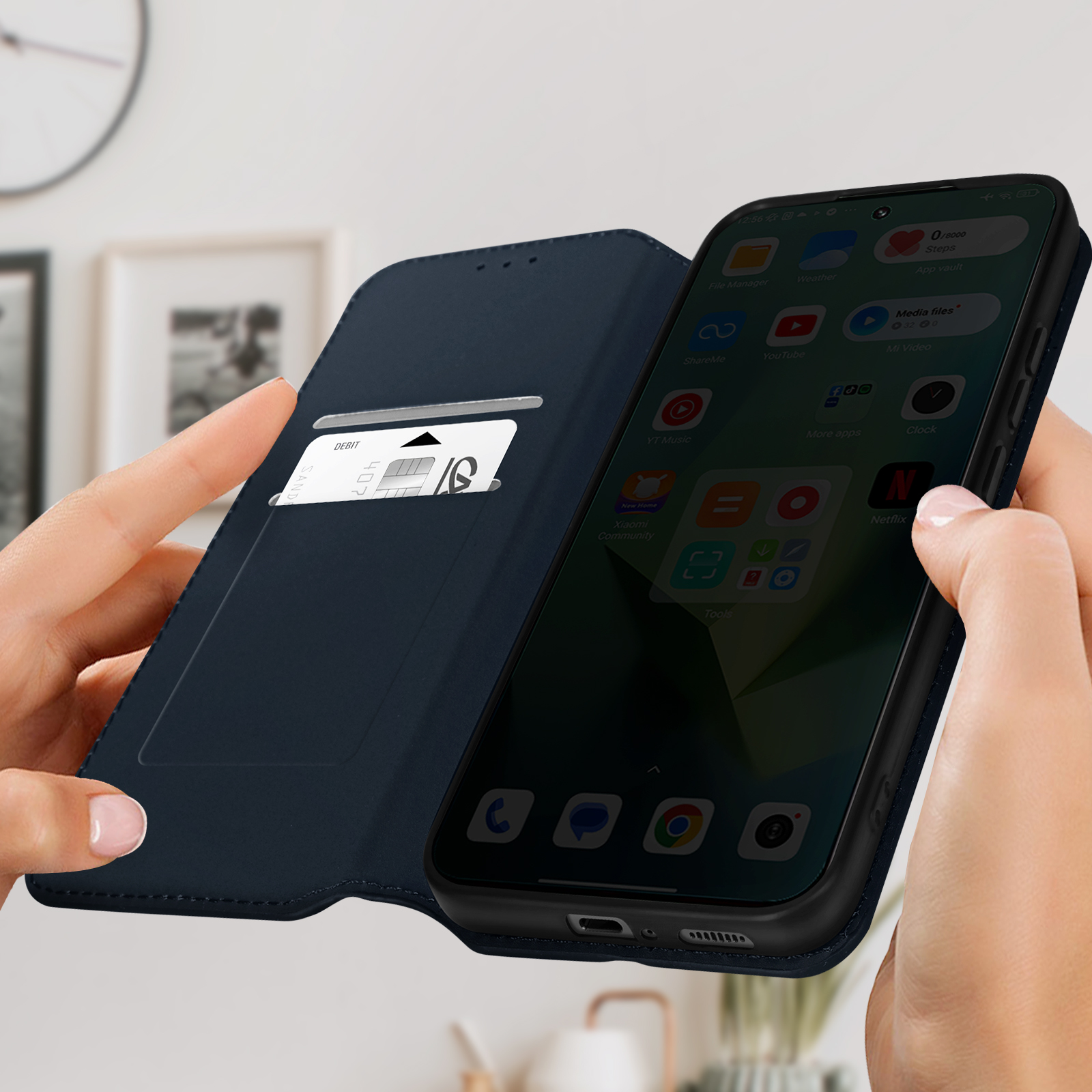 Mani che tengono una custodia blu scuro con telefono, schermo visibile.
