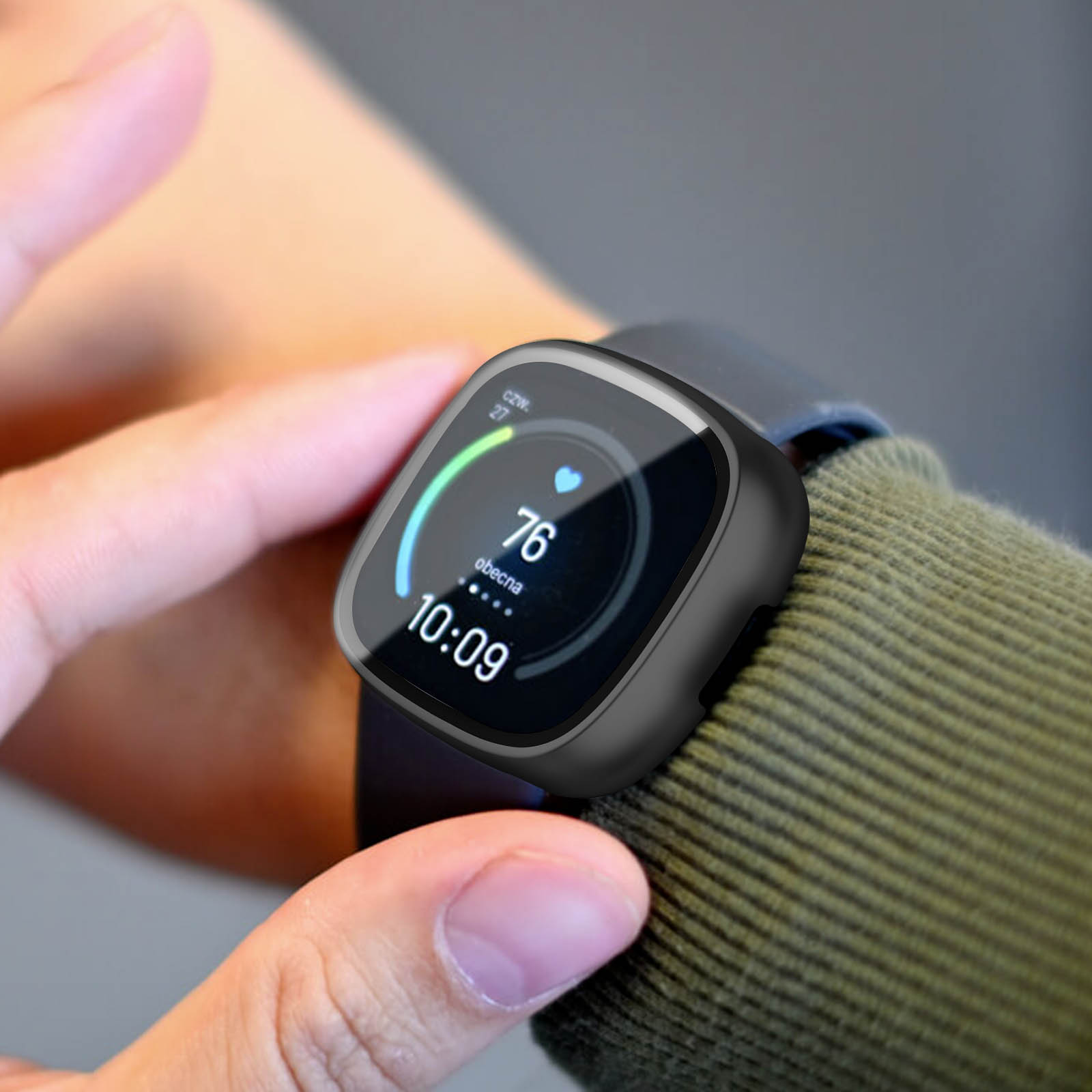 Smartwatch mit Herzfrequenzanzeige am Handgelenk einer Person, grünes Hemd.