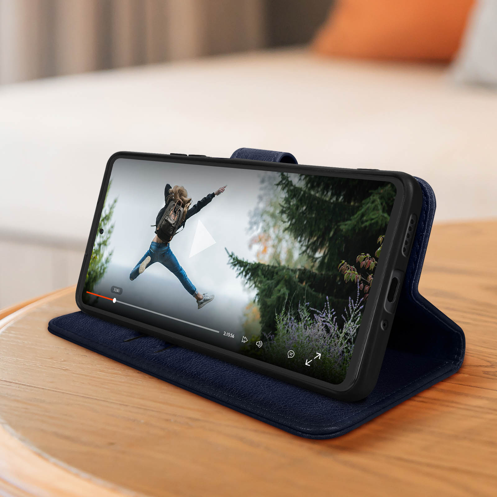 Un telefono cellulare su una custodia blu che mostra un video di una persona che salta.