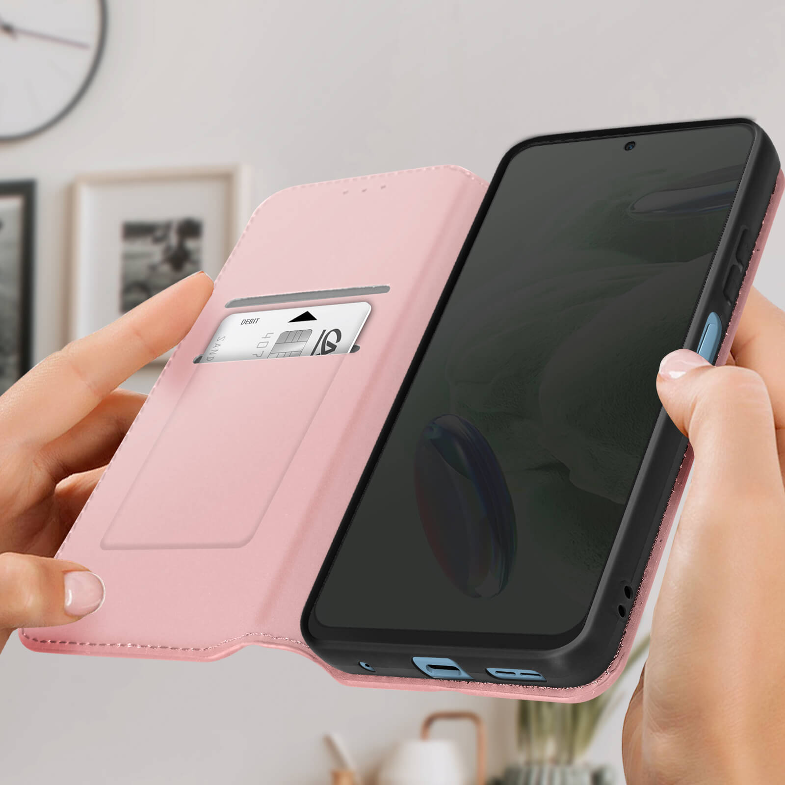Un telefono in una custodia a portafoglio rosa viene tenuto aperto. Una carta di debito è visibile in uno slot.
