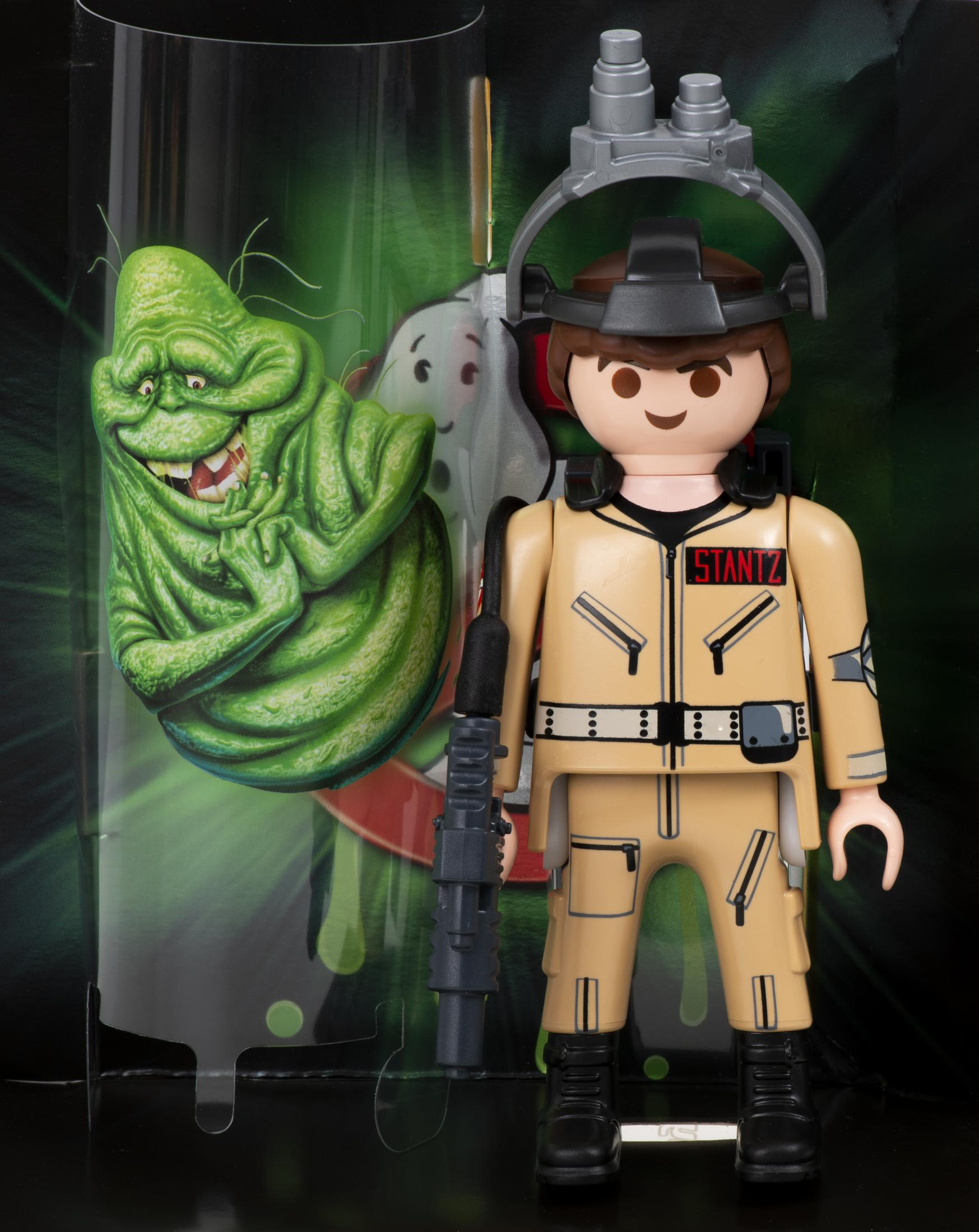 Set Playmobil Ghostbusters con la figura di Stantz e Slimer. Lo sfondo è una vetrina trasparente.