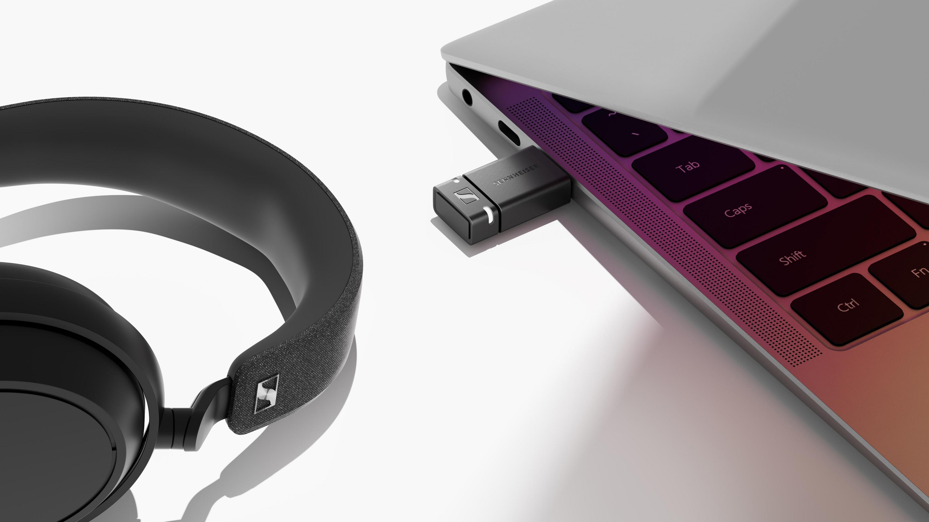 Cuffie e un dongle USB in un laptop. Sfondo bianco. Marchio Sennheiser.