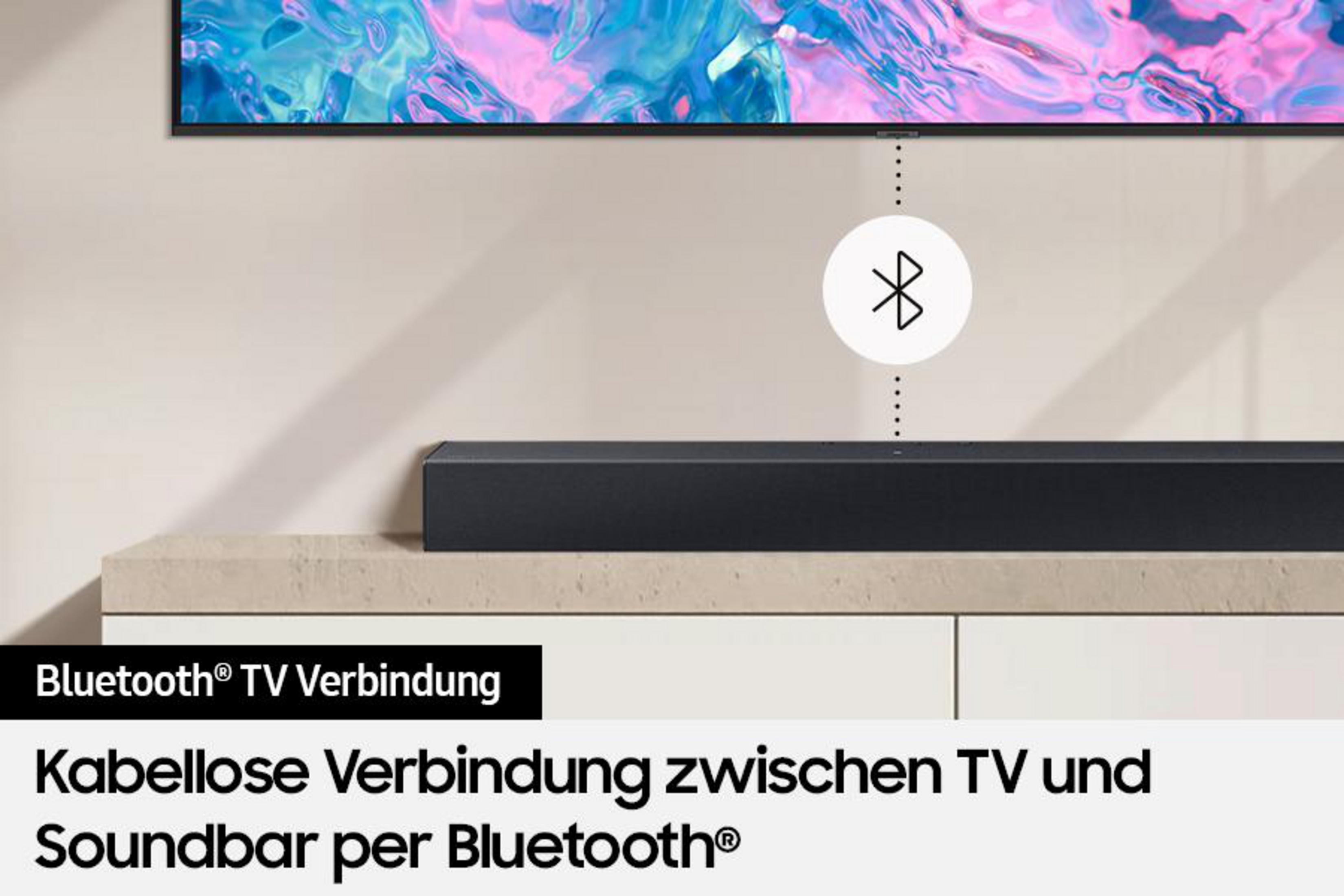 Czarny soundbar umieszczony przed telewizorem. Jest podłączony przez Bluetooth, jak wskazuje tekst.