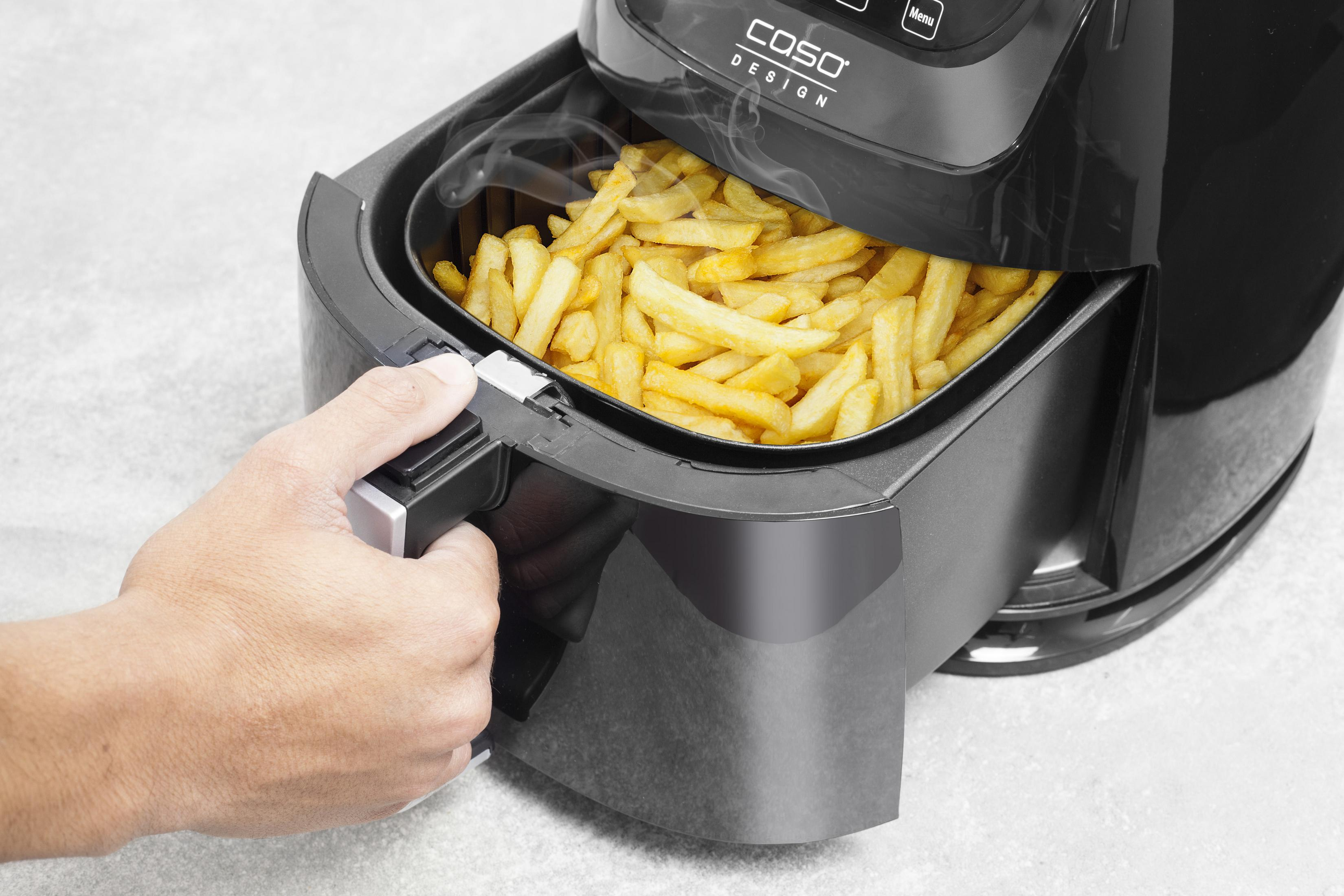 Luftfritteusenschublade mit Pommes Frites, eine Hand hält die Schublade.