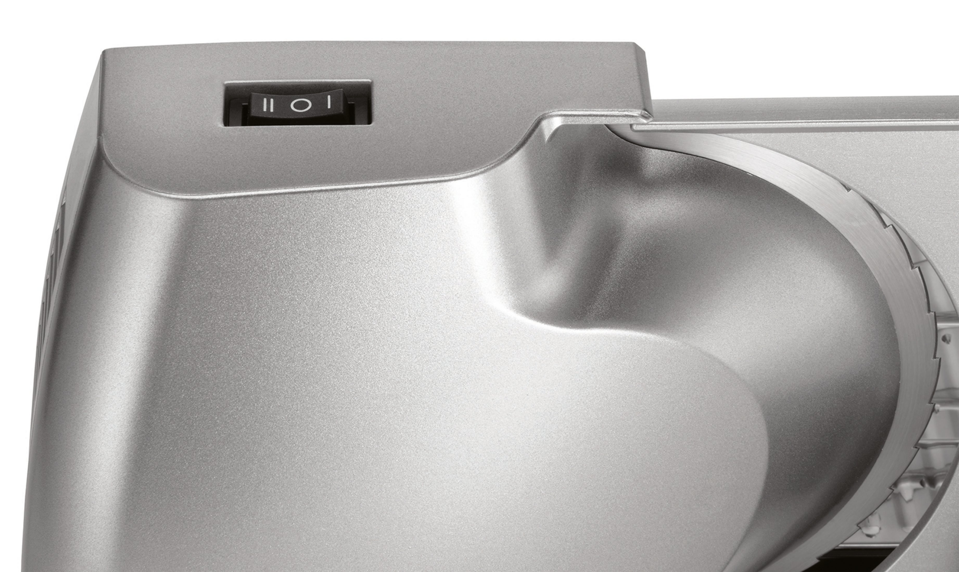 Zbliżenie srebrnej krajalnicy do żywności. Włącznik zasilania znajduje się na górze. Ostrze jest widoczne.