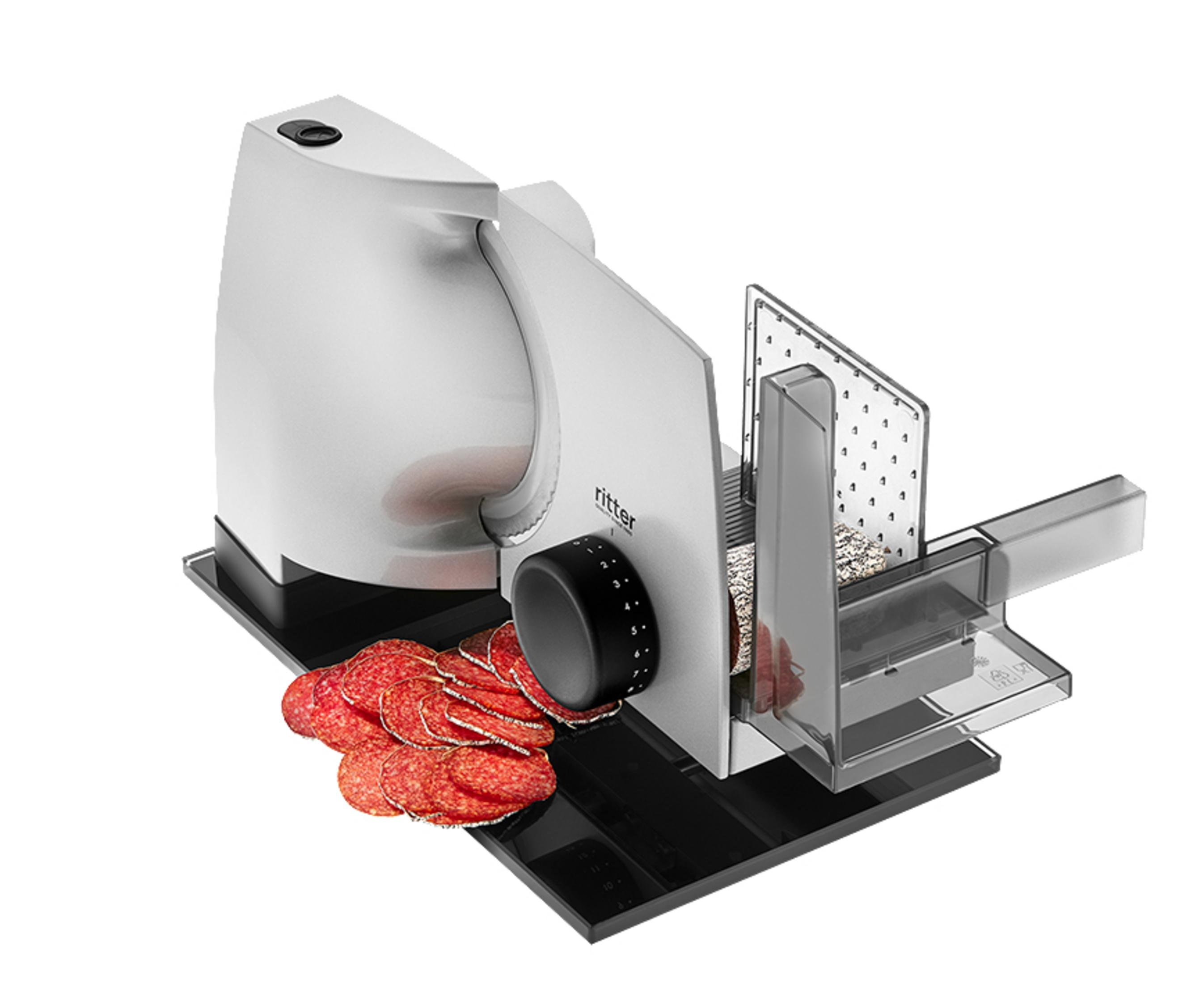 Silberne Fleischschneidemaschine schneidet Salami. Schwarze Basis, Zifferblatt und Griff. Geschnittene Salami und klare Kunststoffschale.